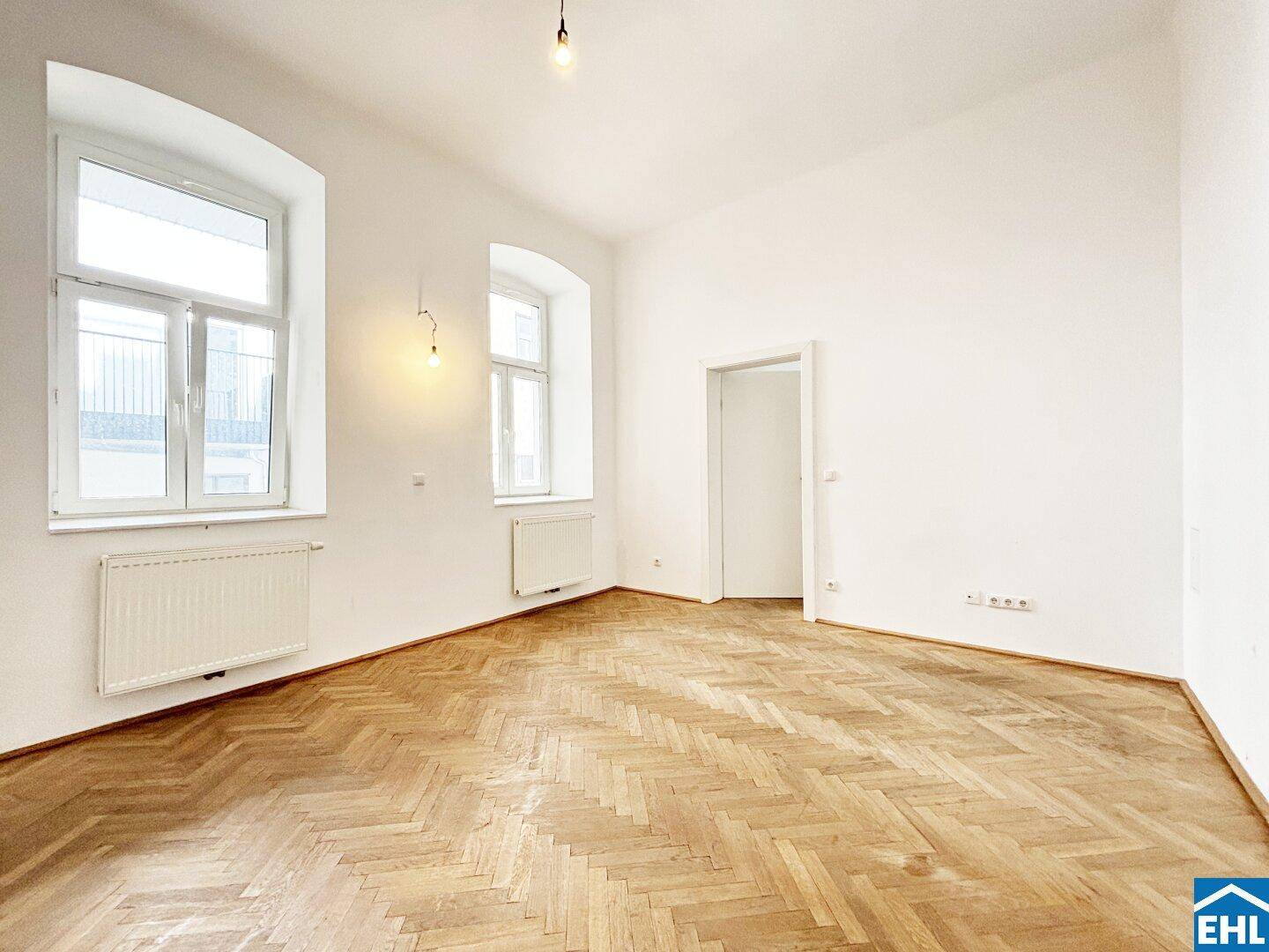 Geräumiges, helles Zimmer mit klassischem Fischgrätparkett und hohen Decken.
