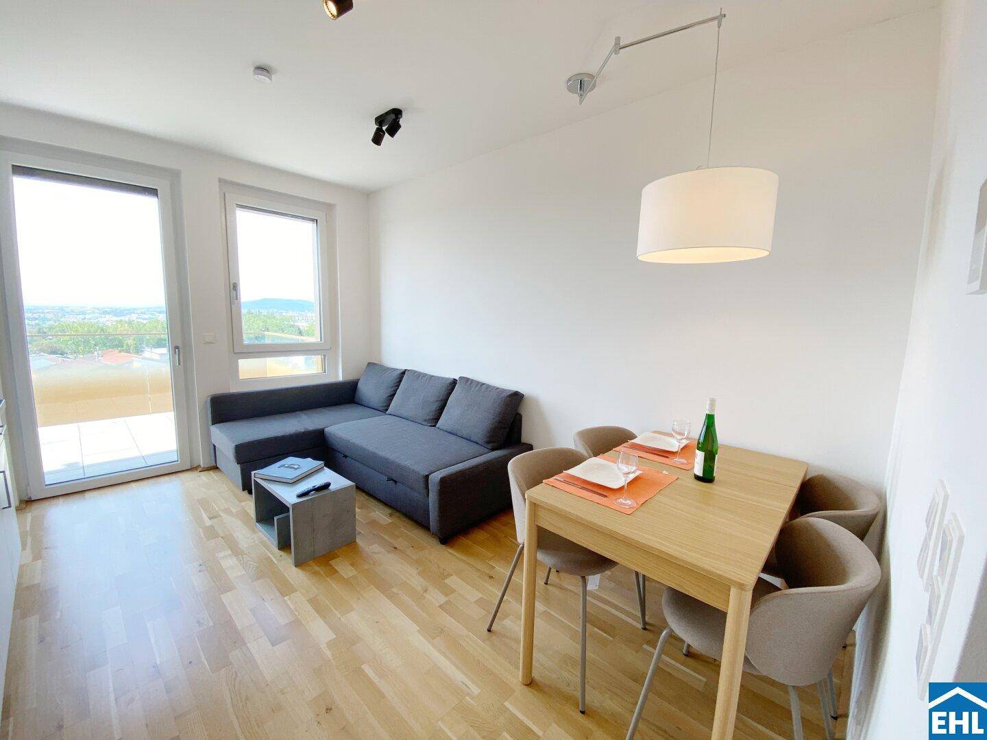 Lichtdurchfluteter Wohn-Essbereich mit modernem Sofa, Esstisch und direktem Zugang zum Balkon.