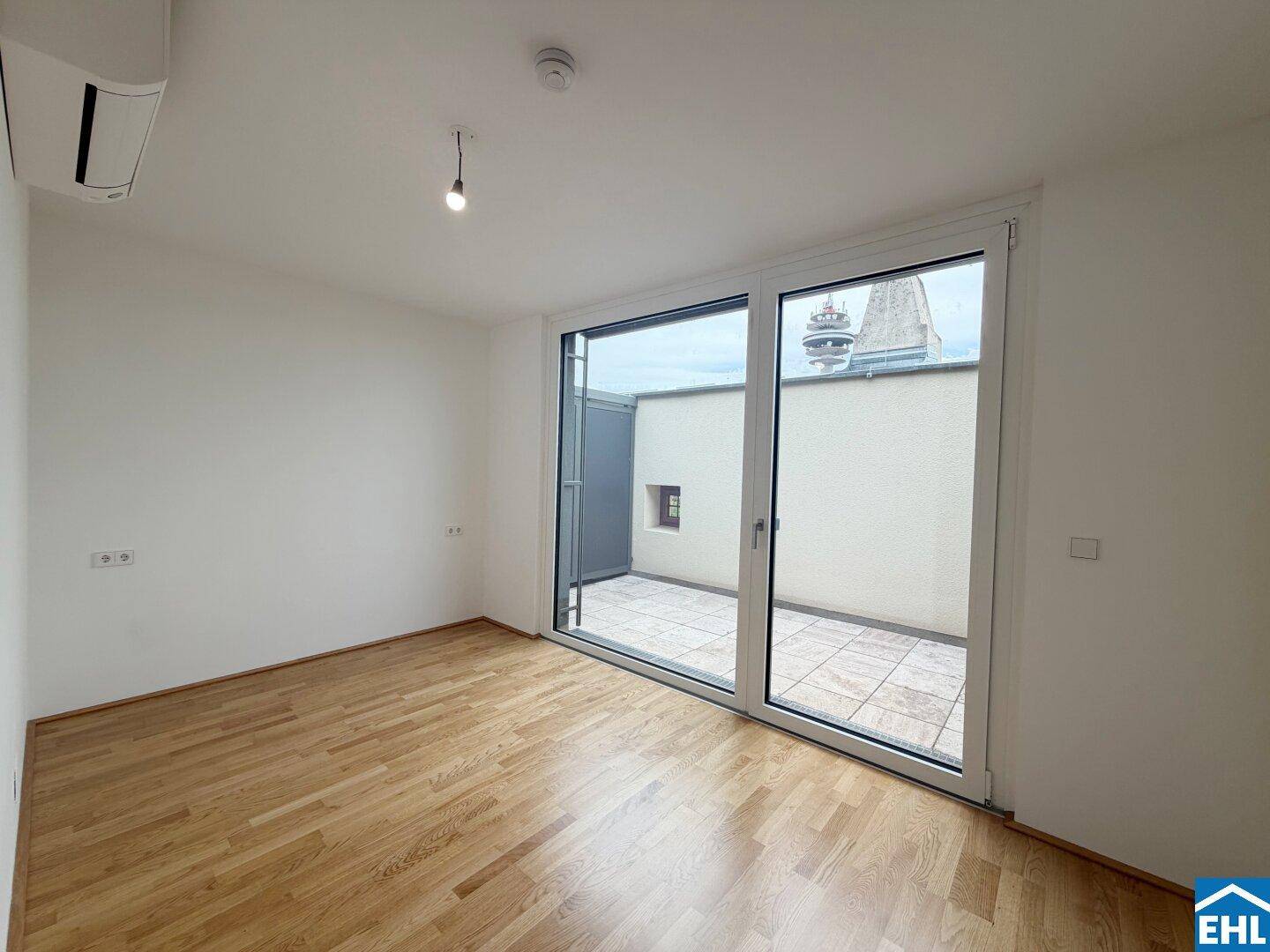 Heller Raum mit Parkettboden und direktem Zugang zu einer privaten Terrasse.