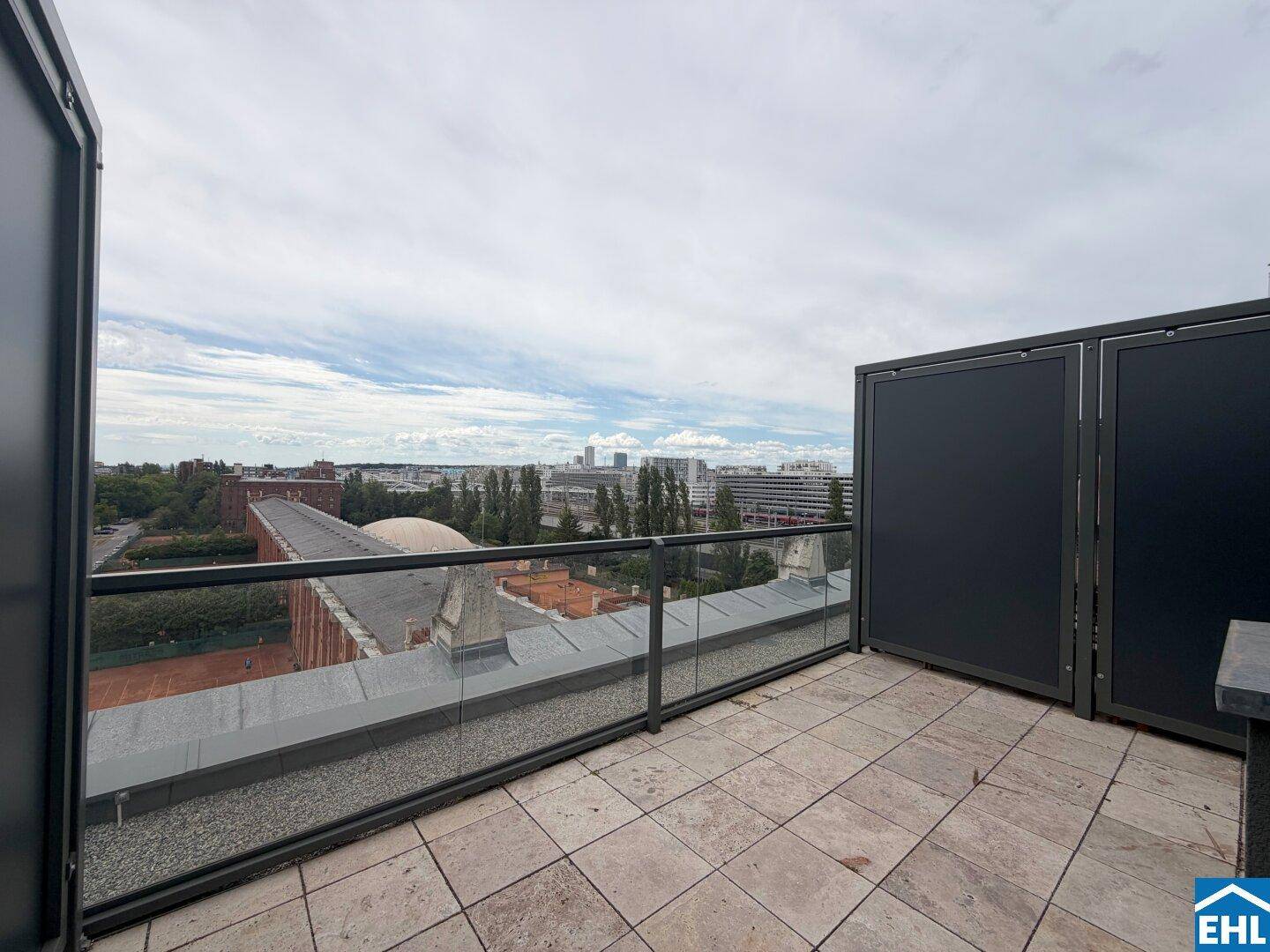 Weitläufige Dachterrasse mit Glasgeländer und beeindruckendem Stadtpanorama.