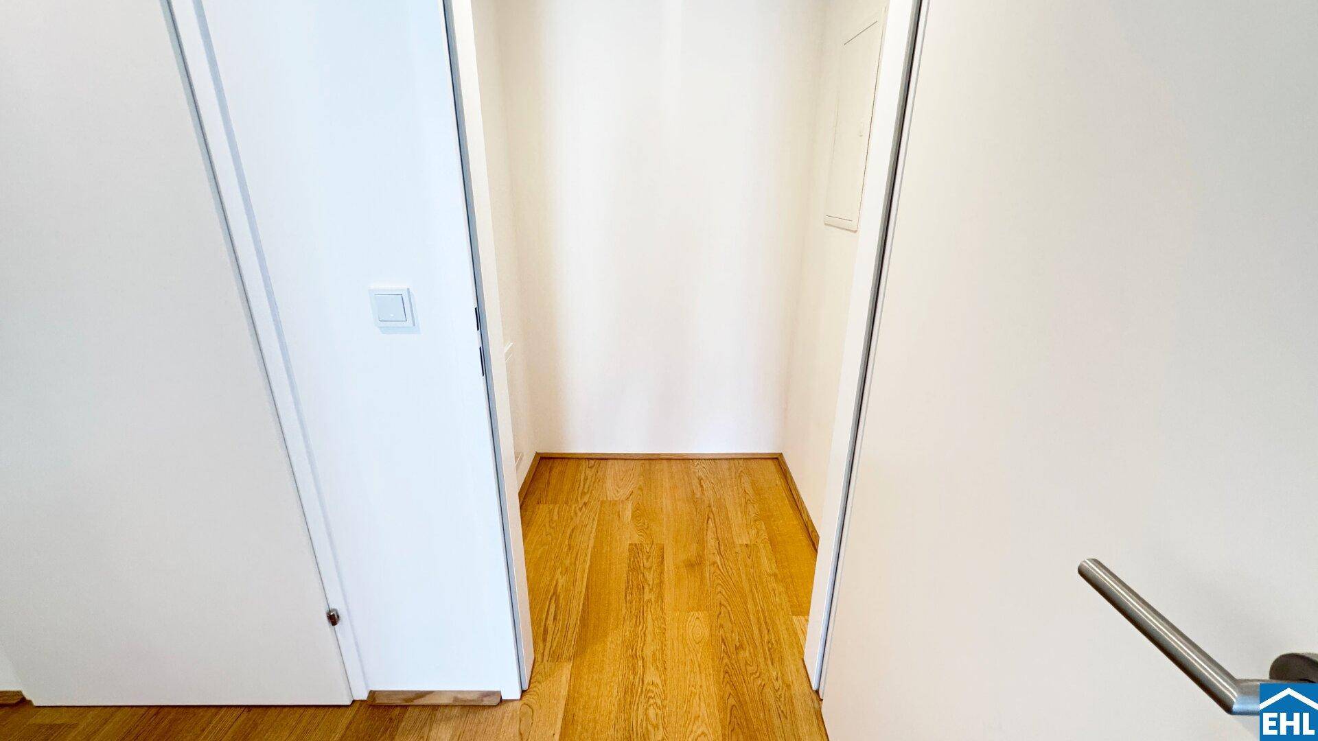 Praktischer Abstellraum mit Holzboden und weißen Wänden, ideal für zusätzlichen Stauraum im Haushalt.