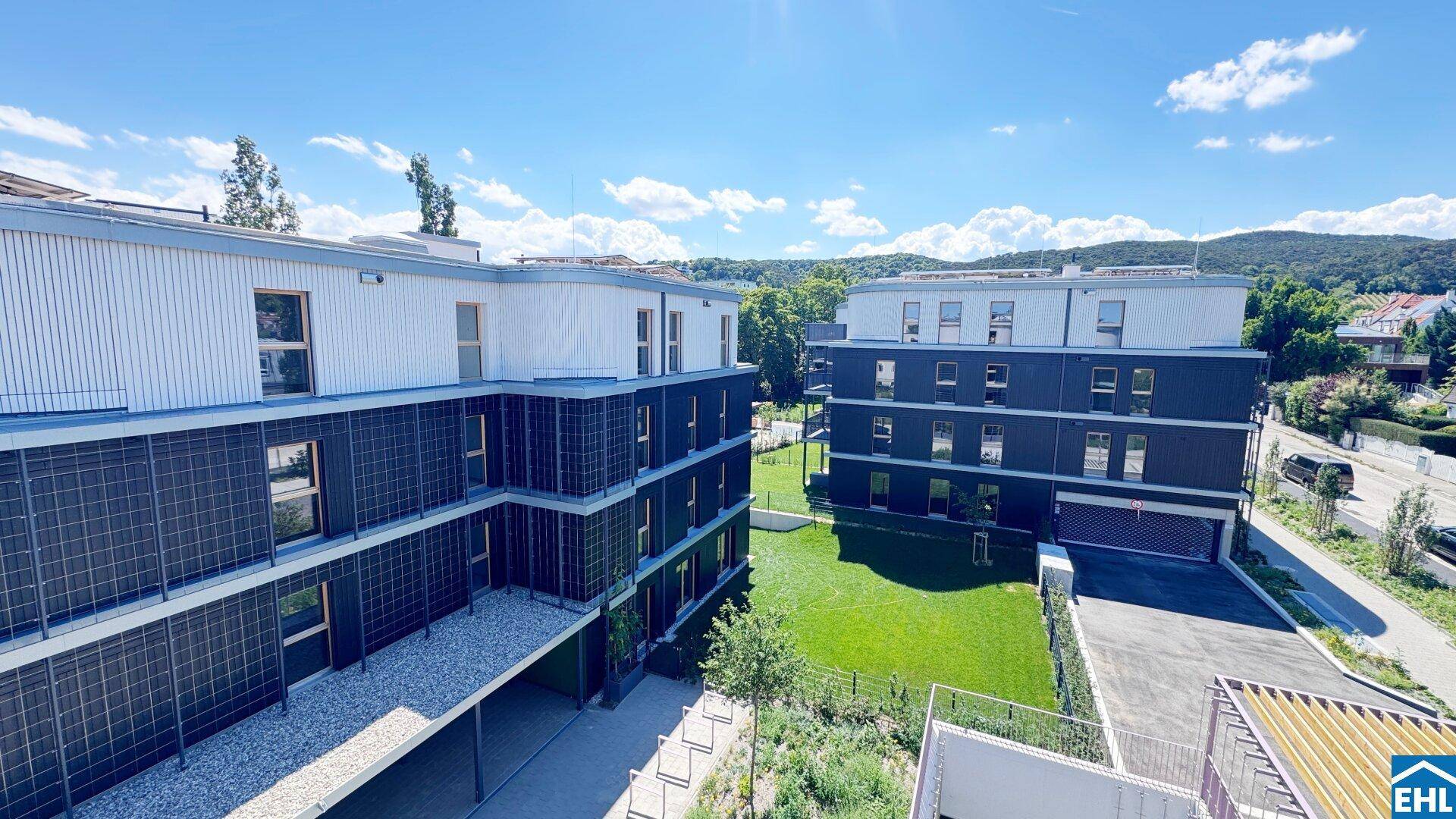 Moderne Wohngebäude mit ansprechender Architektur, großen Fenstern und grünen Außenbereichen.