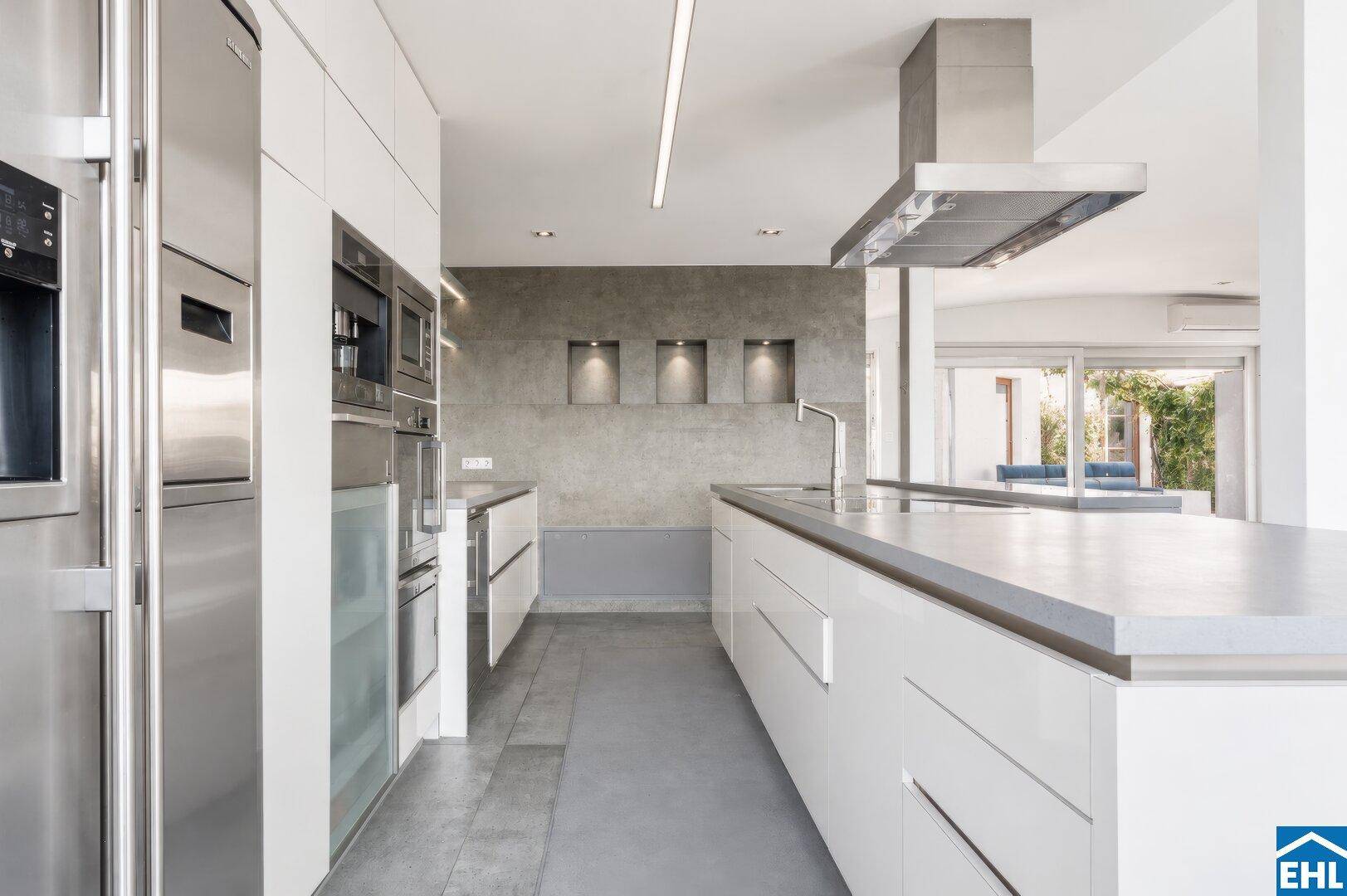 Elegante Küche mit weißen Fronten, integrierten Geräten und minimalistischem Design.