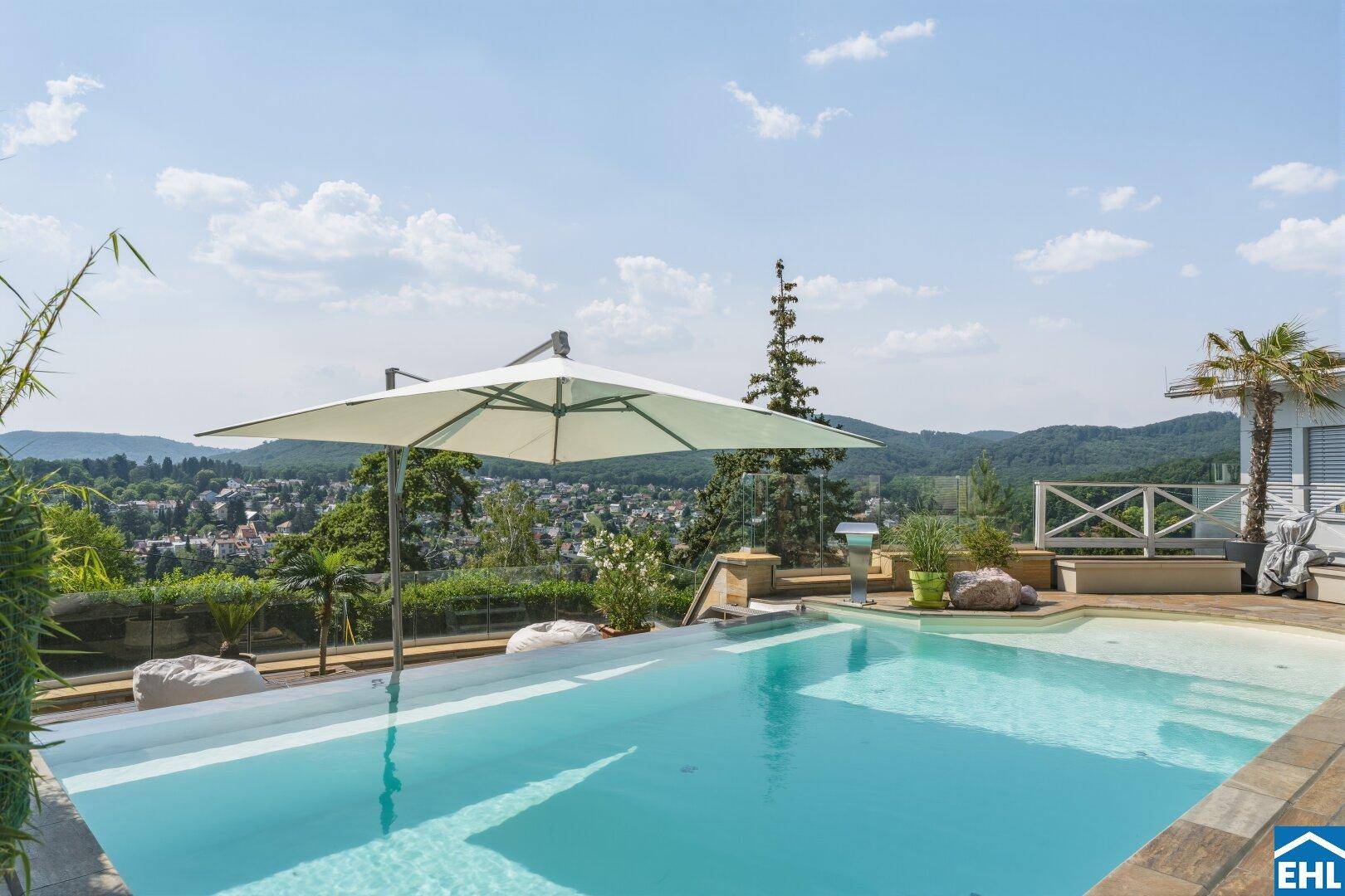 Infinity-Pool mit atemberaubendem Panoramablick über die grüne Hügellandschaft und die Stadt.