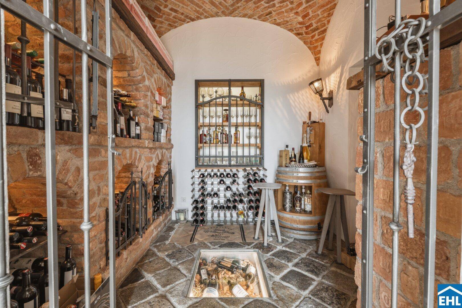 Rustikaler Weinkeller mit Ziegelgewölbe, Steinboden und umfangreicher Weinsammlung.