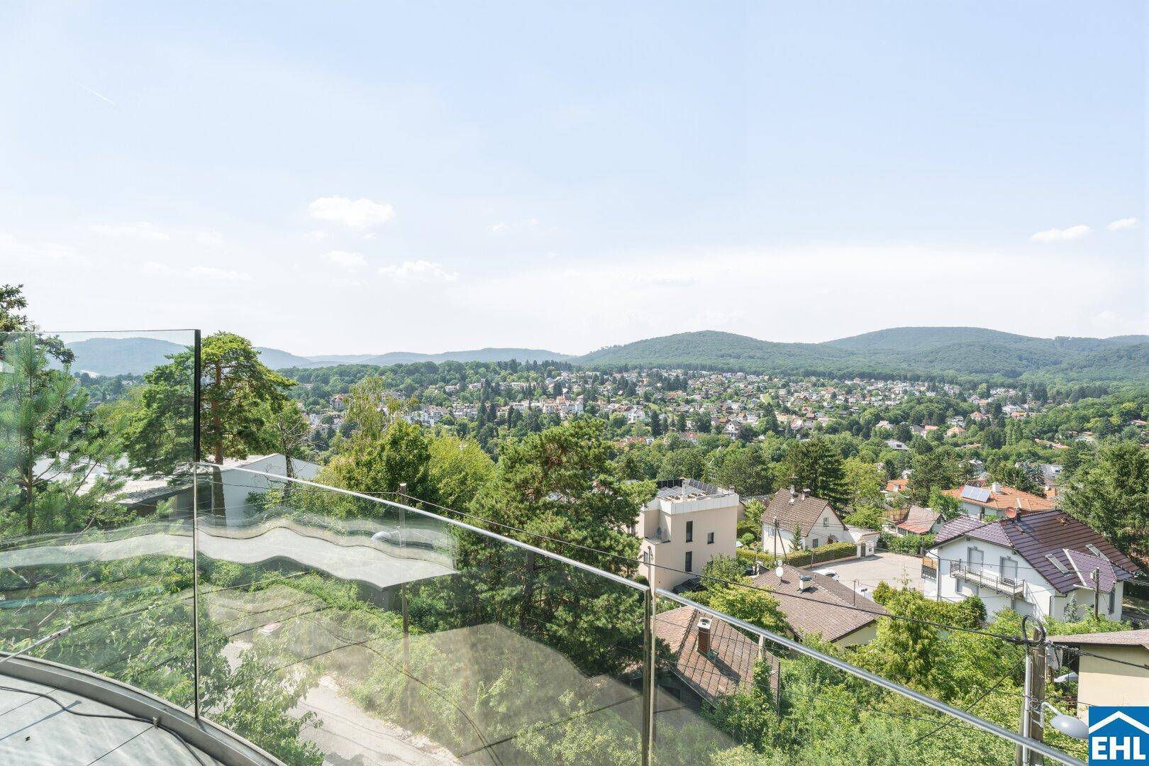 Panoramablick von der Terrasse über die Stadt und die umliegende grüne Hügellandschaft.