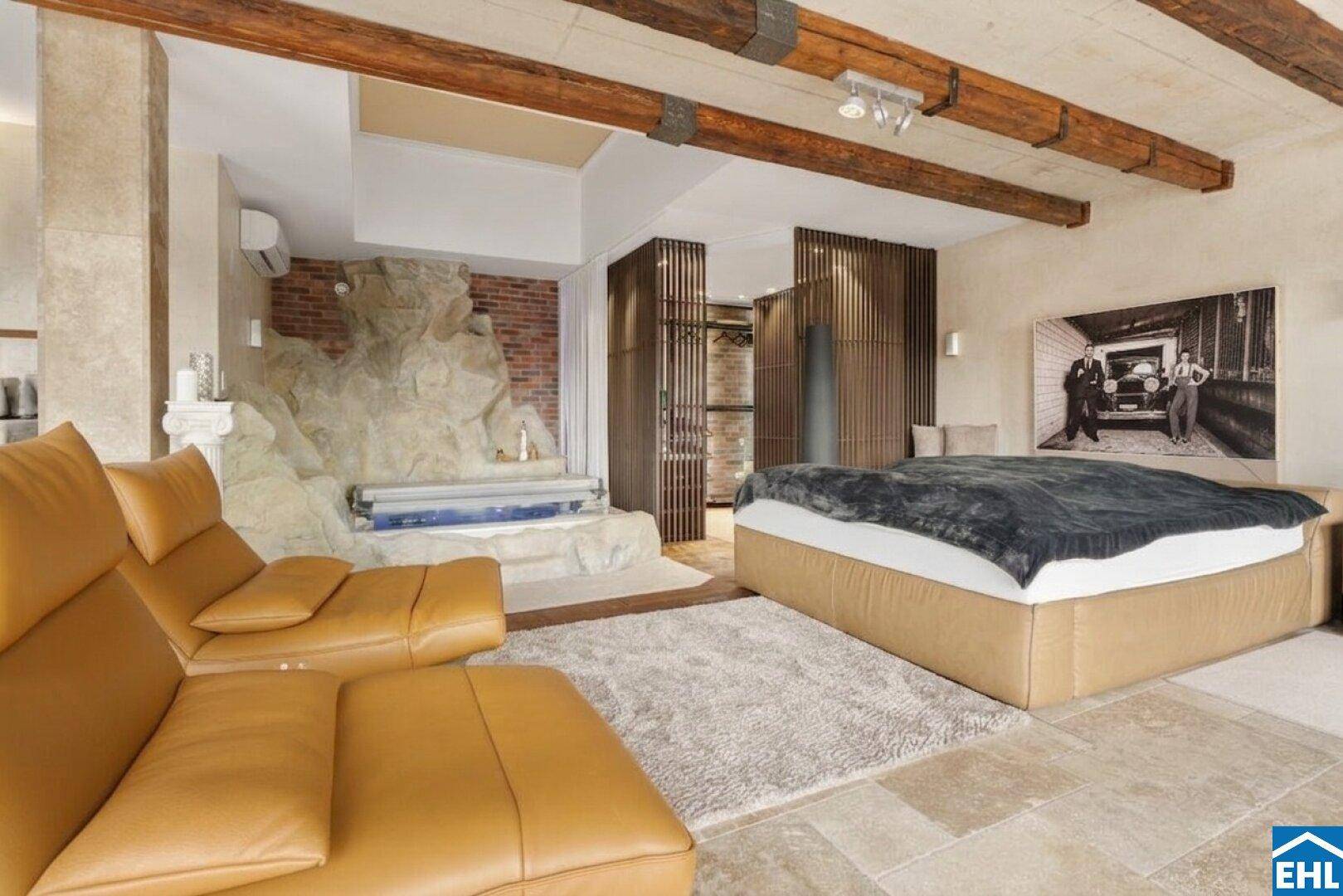 Luxuriöses Schlafzimmer mit integriertem Whirlpool, Holzbalken und Natursteinboden.
