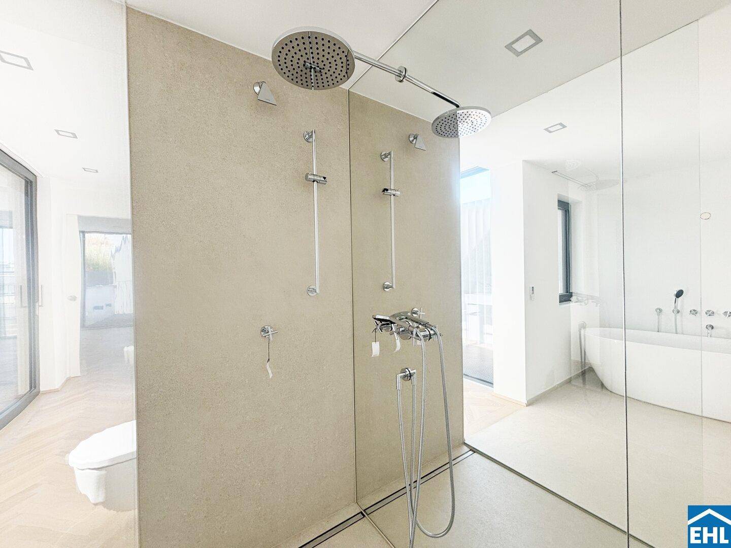 Luxuriöses Badezimmer mit großer begehbarer Regendusche und freistehender Badewanne.