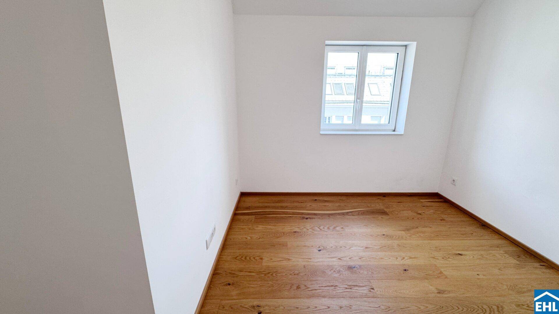Helles Zimmer mit Holzboden und Fenster, ideal als Schlaf- oder Arbeitszimmer.