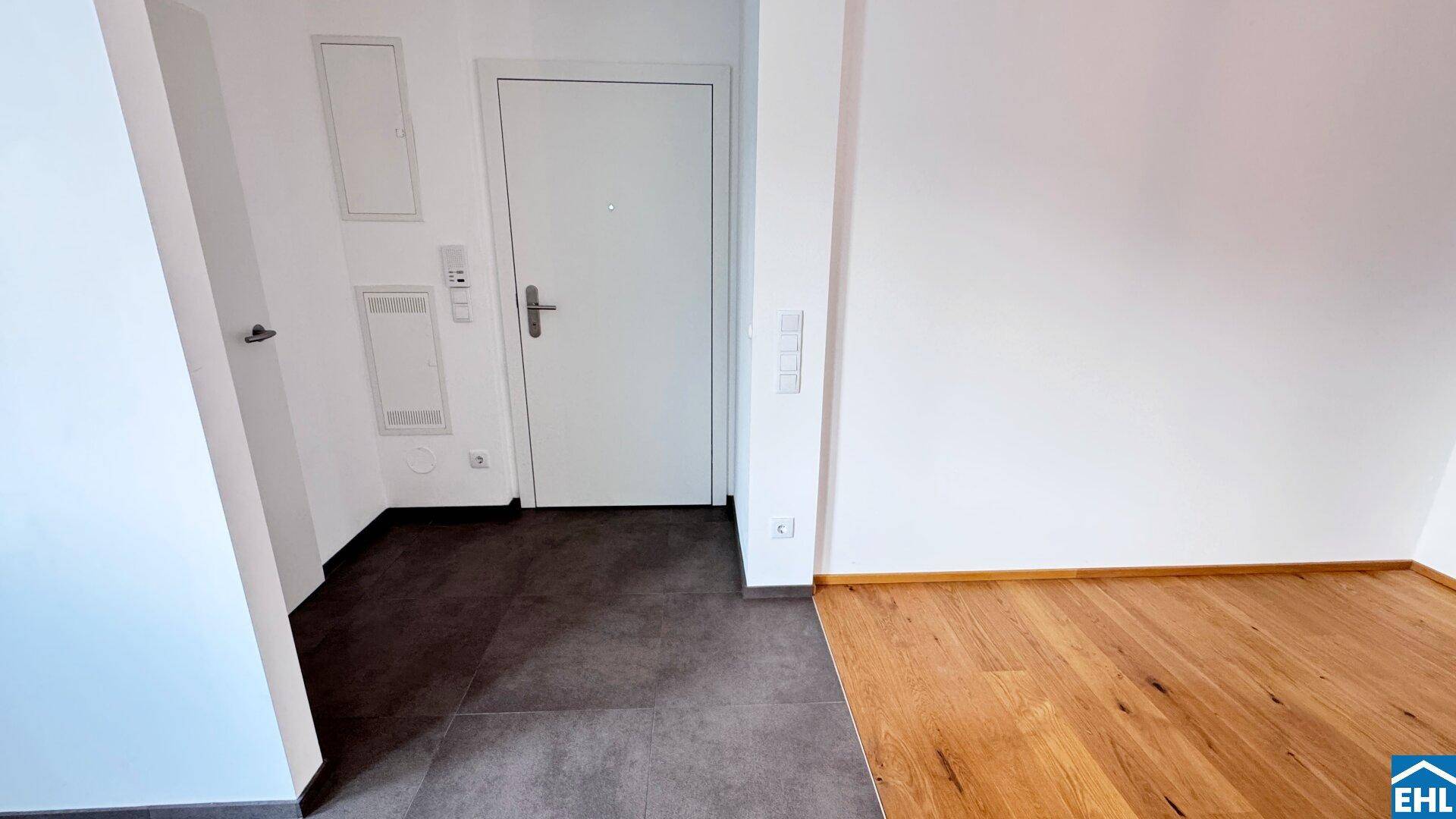 Eingangsbereich mit Fliesenboden und Holzboden, führt in den Wohnbereich.