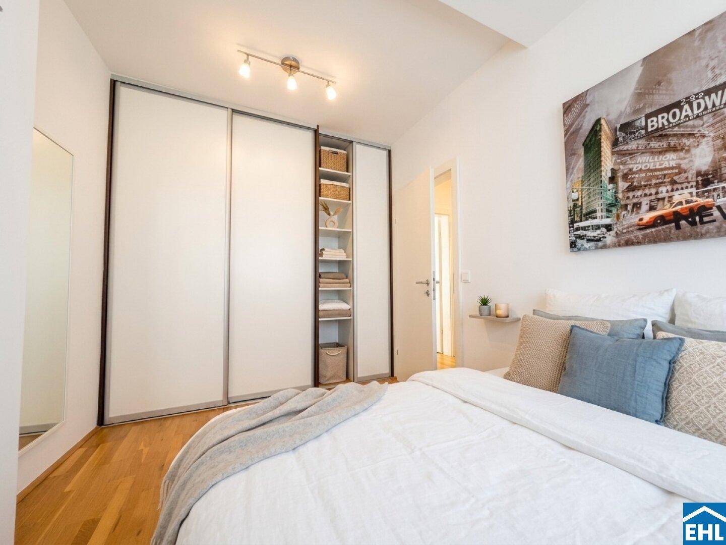 Schlafzimmer mit großem Einbauschrank, Holzboden und modernem Wandbild.