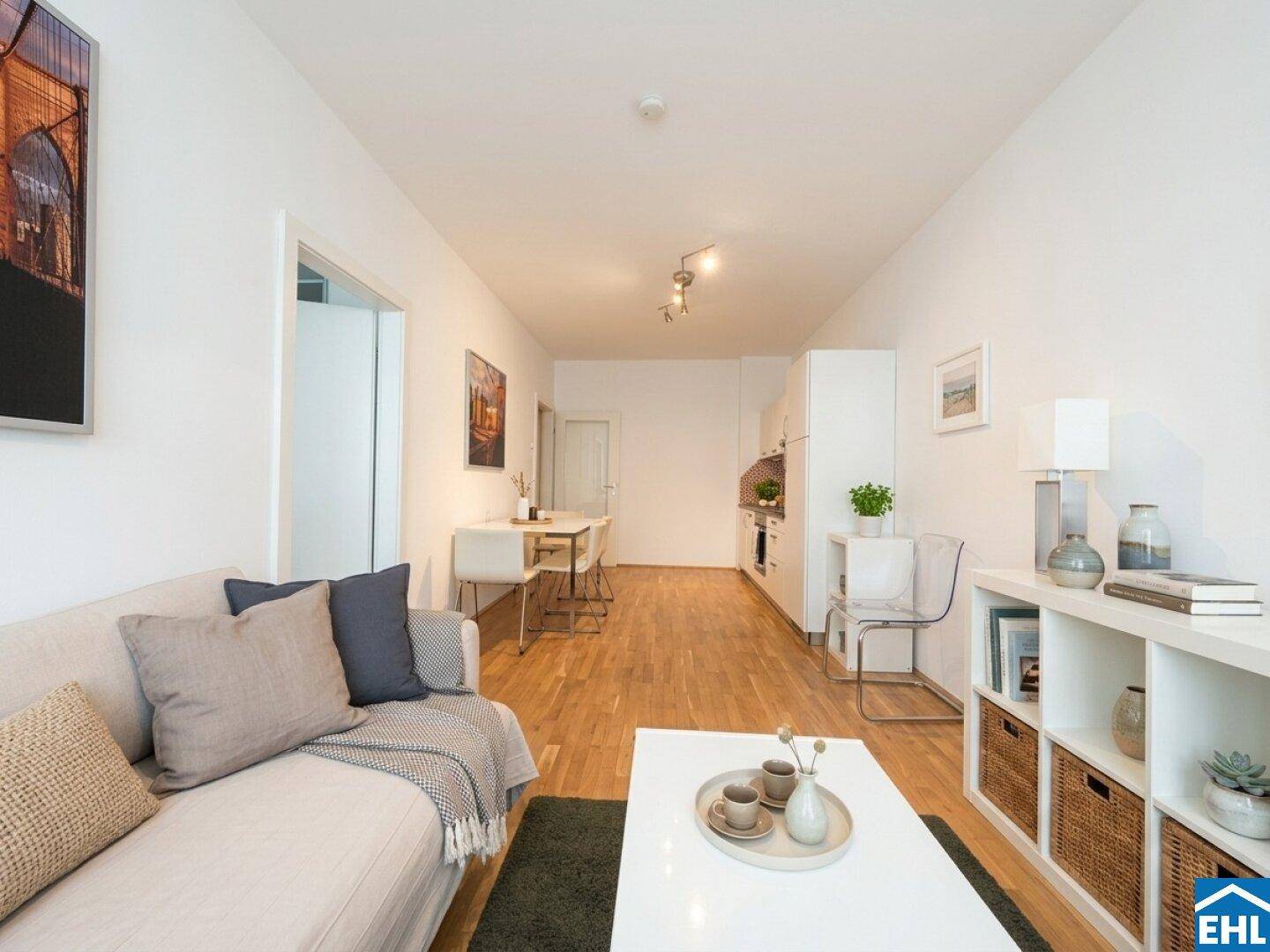 Gemütlicher Wohnbereich mit Sofa, Esstisch und Blick zur integrierten Küchenzeile.