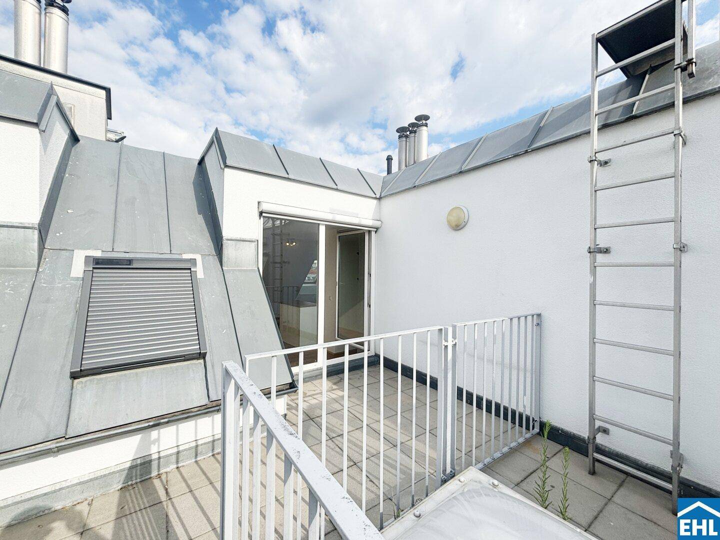Dachterrasse mit Zugang zum Innenbereich und Blick auf die umliegenden Dächer.
