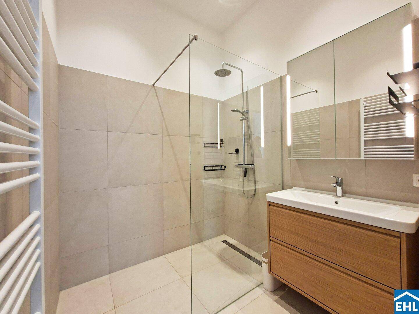 Modernes Badezimmer mit begehbarer Dusche, Einzelwaschbecken und beheiztem Handtuchhalter.