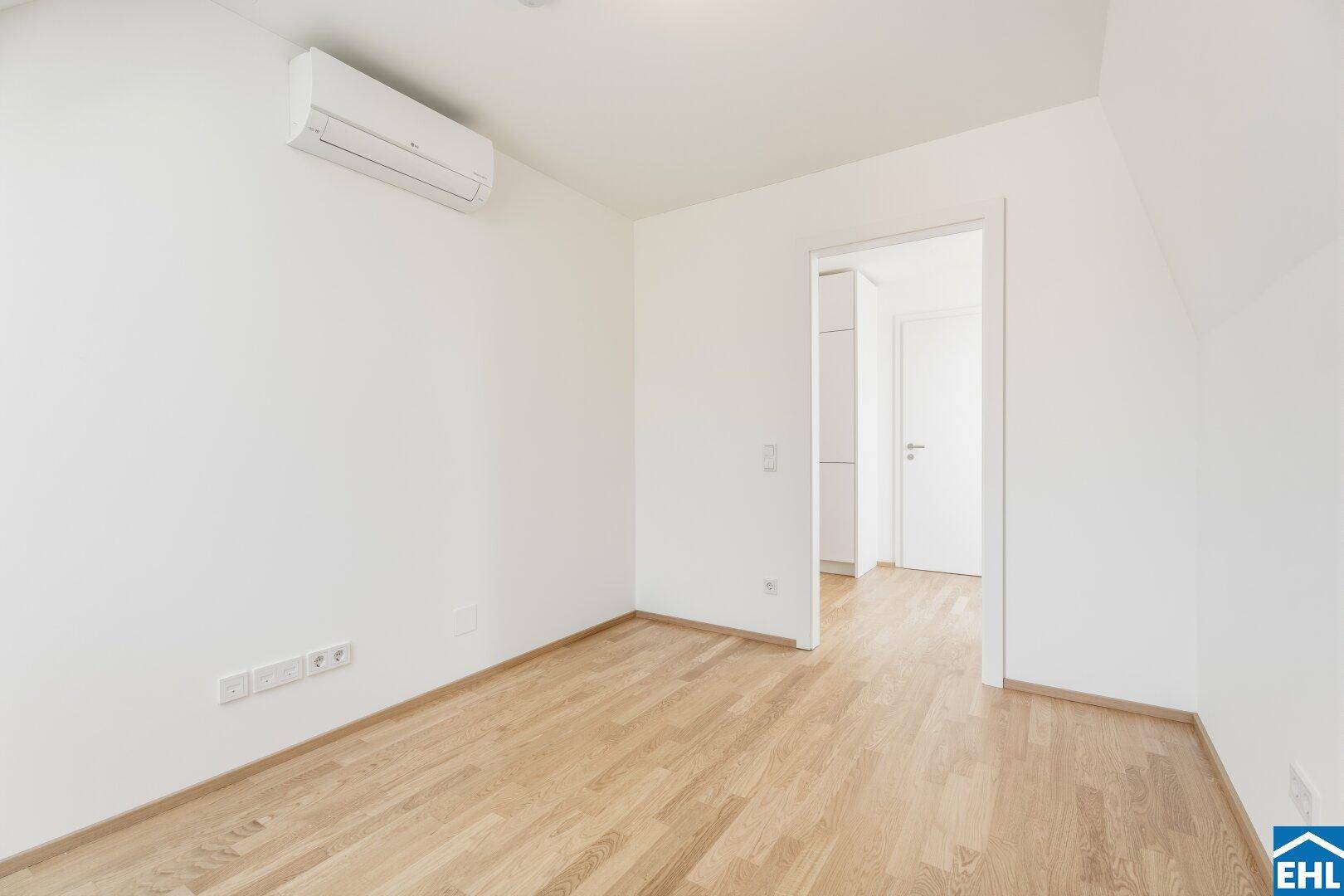 Geräumiger Raum mit Holzboden und Klimaanlage, der vielseitig nutzbar ist.