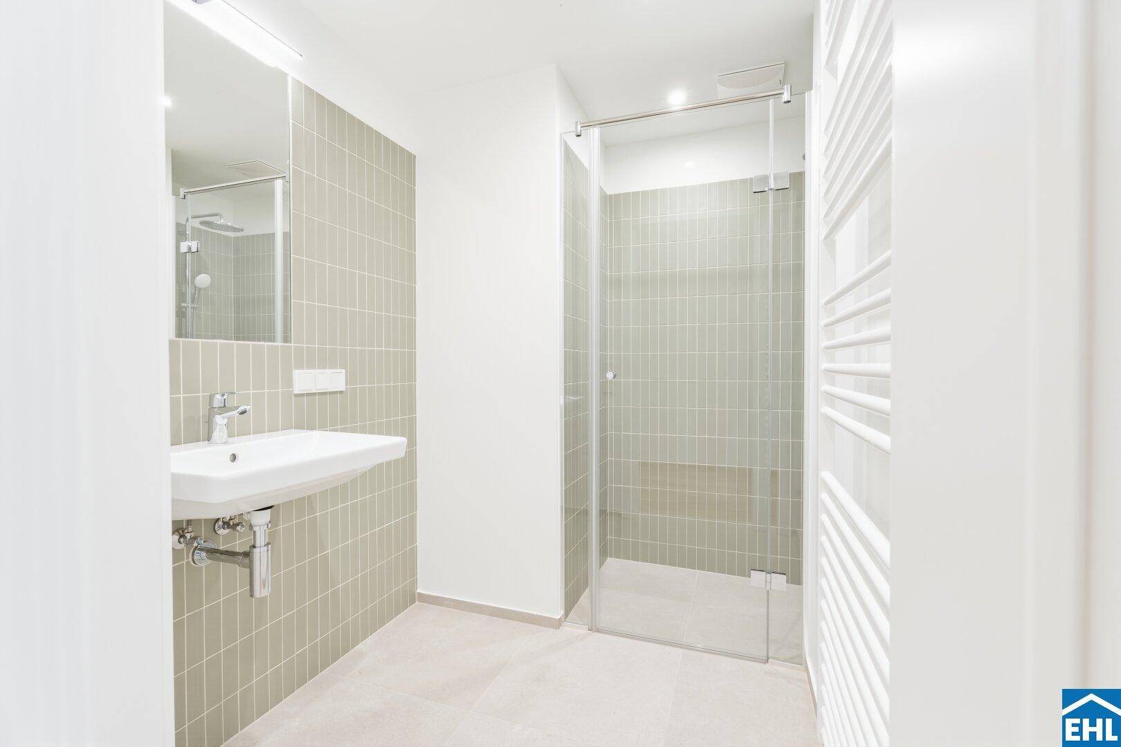 Modernes Badezimmer mit Einzelwaschbecken, begehbarer Dusche und beheiztem Handtuchhalter.