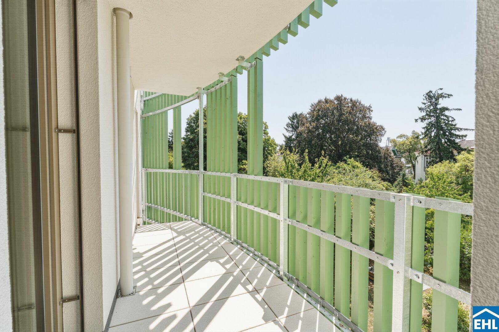 Geräumiger Balkon mit grünen Geländern und Blick auf die umliegende Natur.