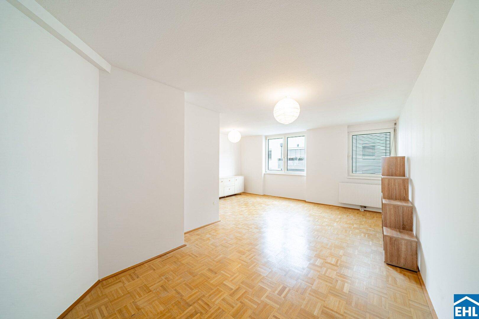 Helles Zimmer mit Parkettboden und zwei Fenstern, vielseitig nutzbar als Schlaf- oder Wohnraum.