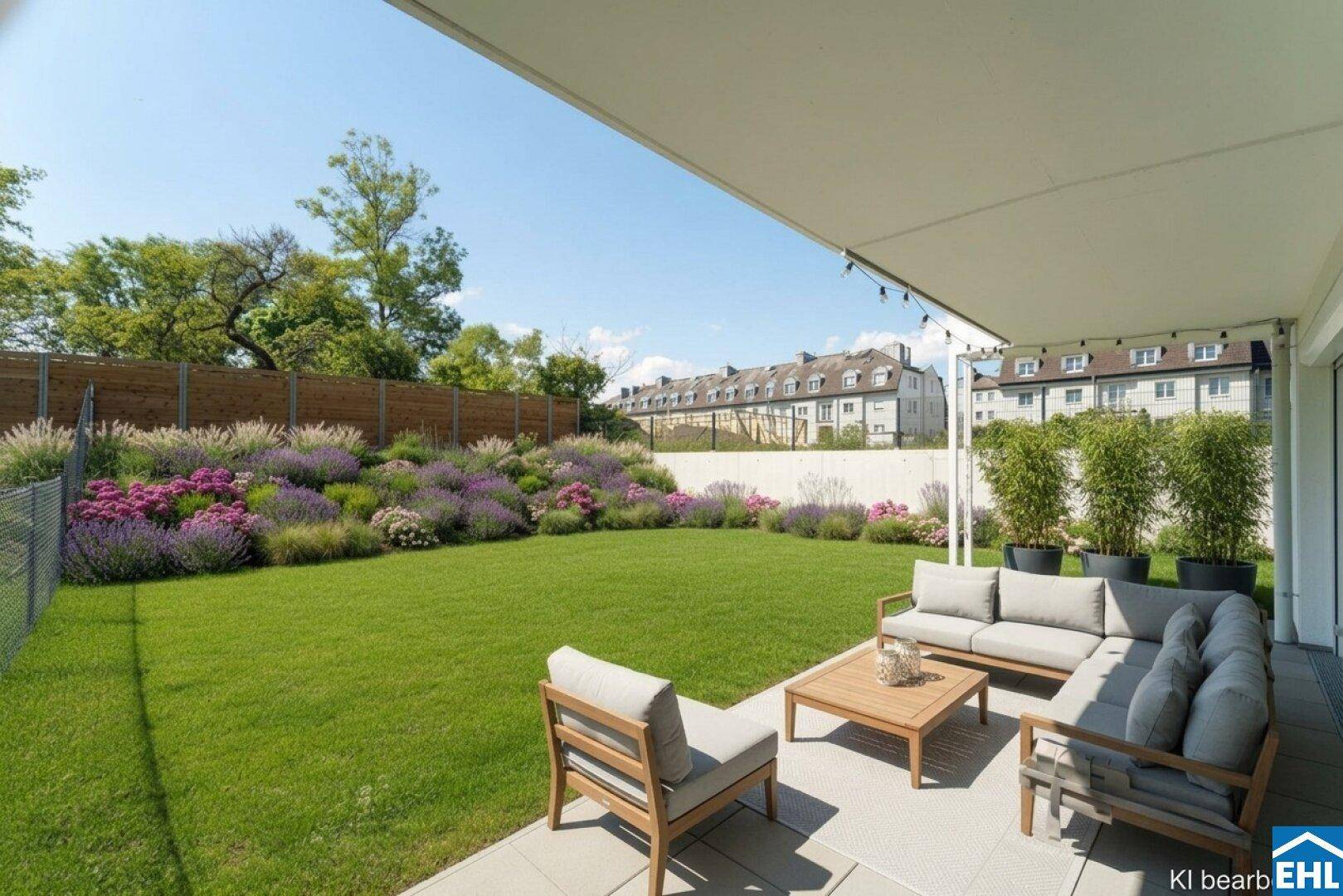Geräumige Terrasse mit Lounge-Möbeln, großer Rasenfläche und blühenden Blumenbeeten.