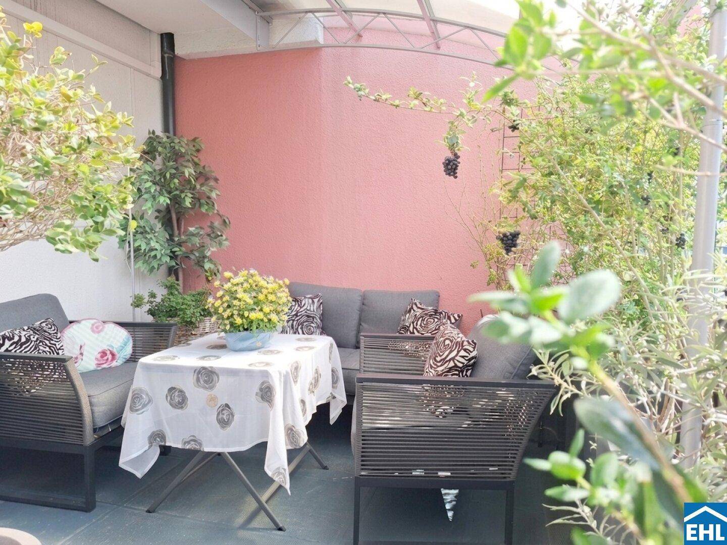Möblierte Terrasse mit bequemen Sitzgelegenheiten und üppiger Bepflanzung für gesellige Stunden.
