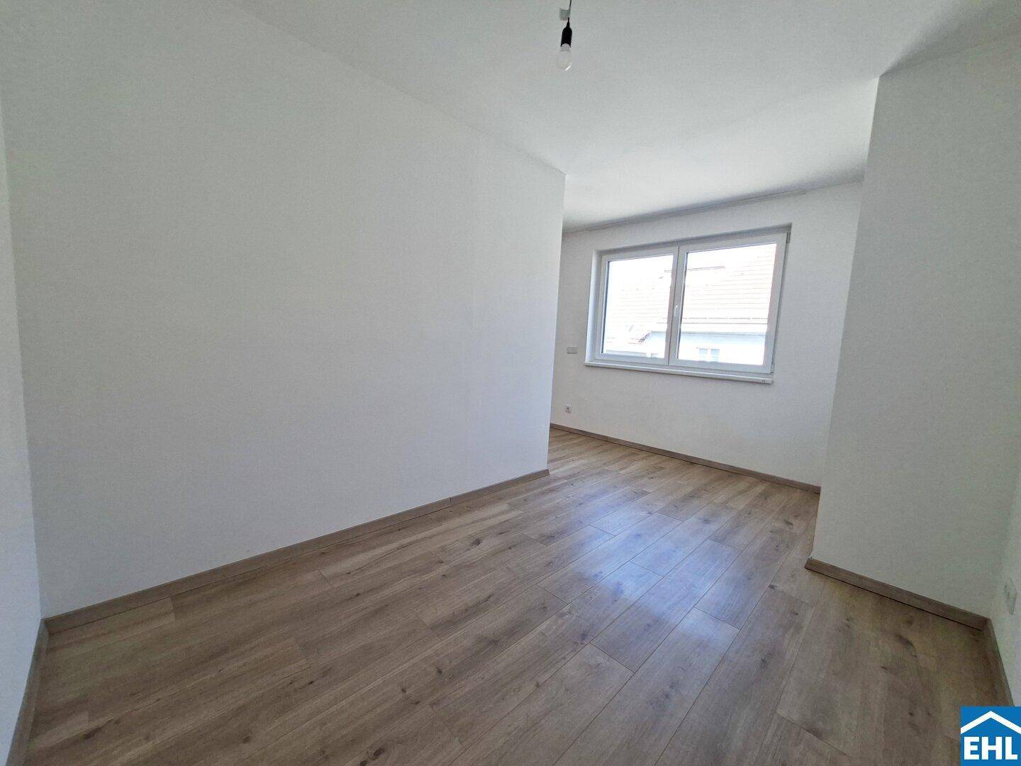 Helles Zimmer mit Fenster und Laminatboden, ideal als Schlaf- oder Arbeitszimmer.