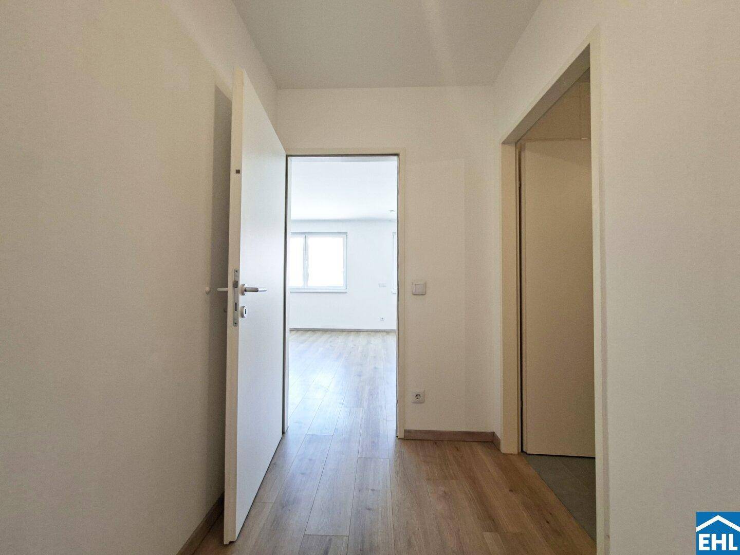 Heller Flur mit Laminatboden und Zugang zu weiteren Räumen der Wohnung.