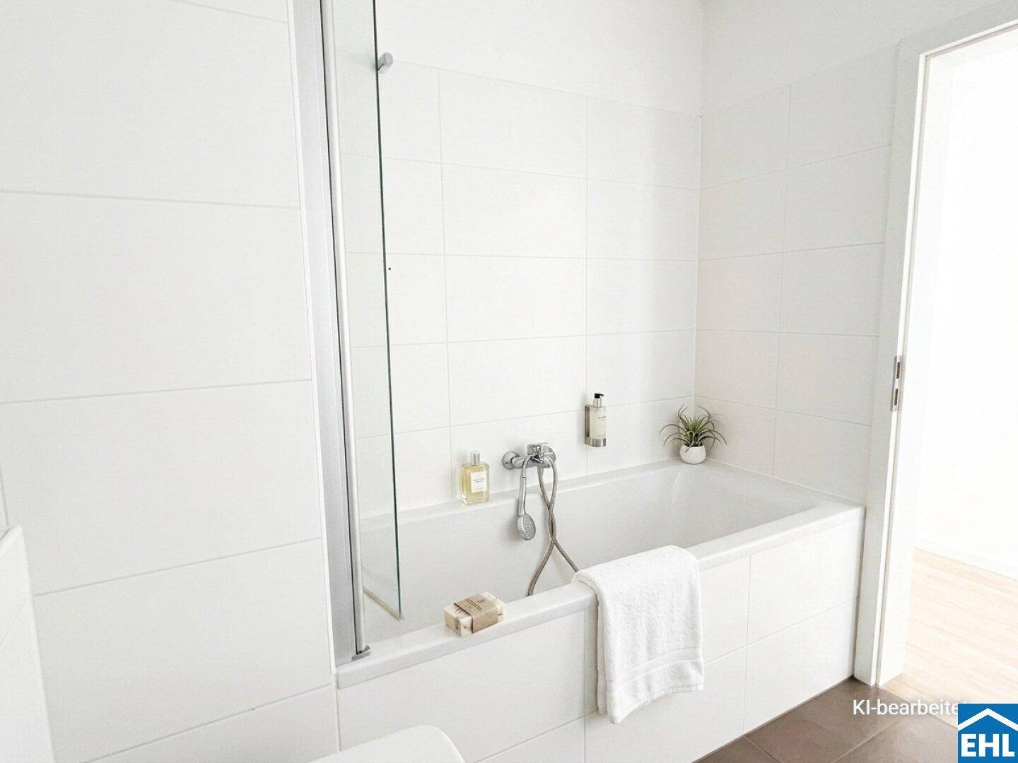 Modernes Badezimmer mit weiß gefliesten Wänden und einer Badewanne mit Duschabtrennung.