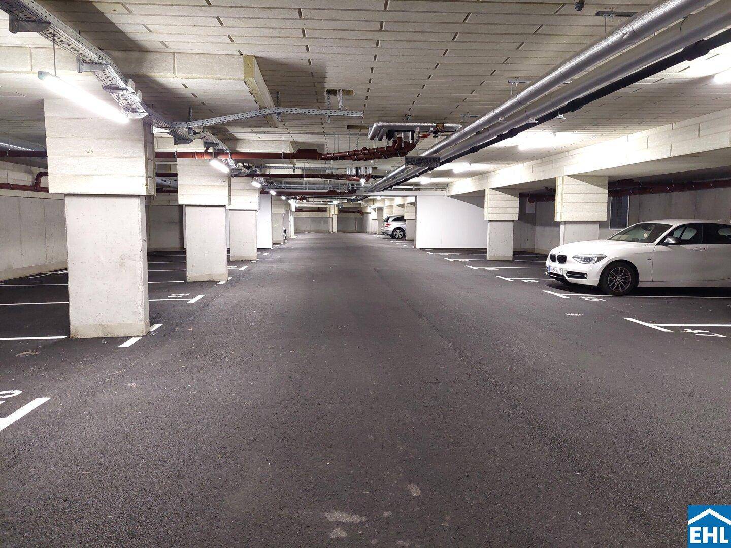 Geräumige Tiefgarage mit Betonpfeilern und markierten Stellplätzen für Fahrzeuge.