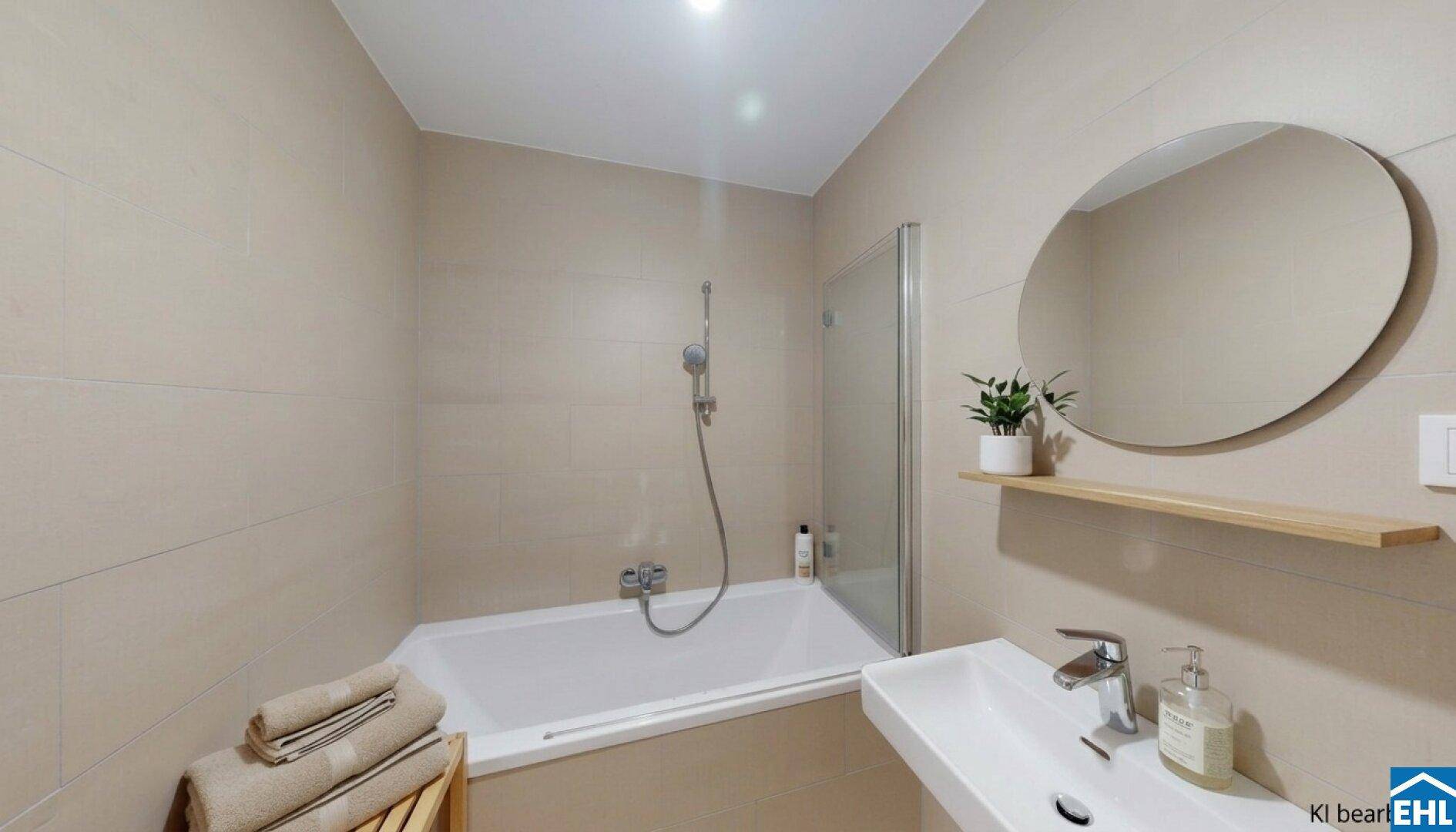 Modernes Badezimmer mit beigefarbenen Fliesen, Badewanne und integrierter Dusche.