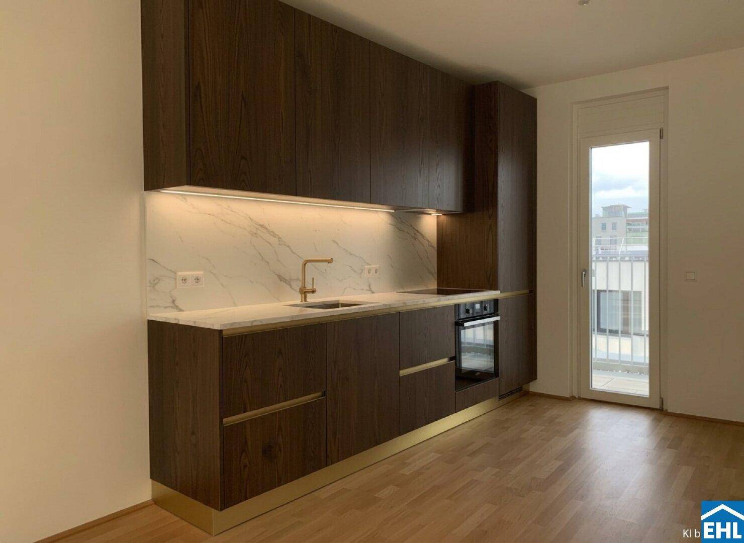 Moderne Einbauküche mit dunklen Holzfronten, Marmor-Arbeitsplatte und Zugang zum Balkon.