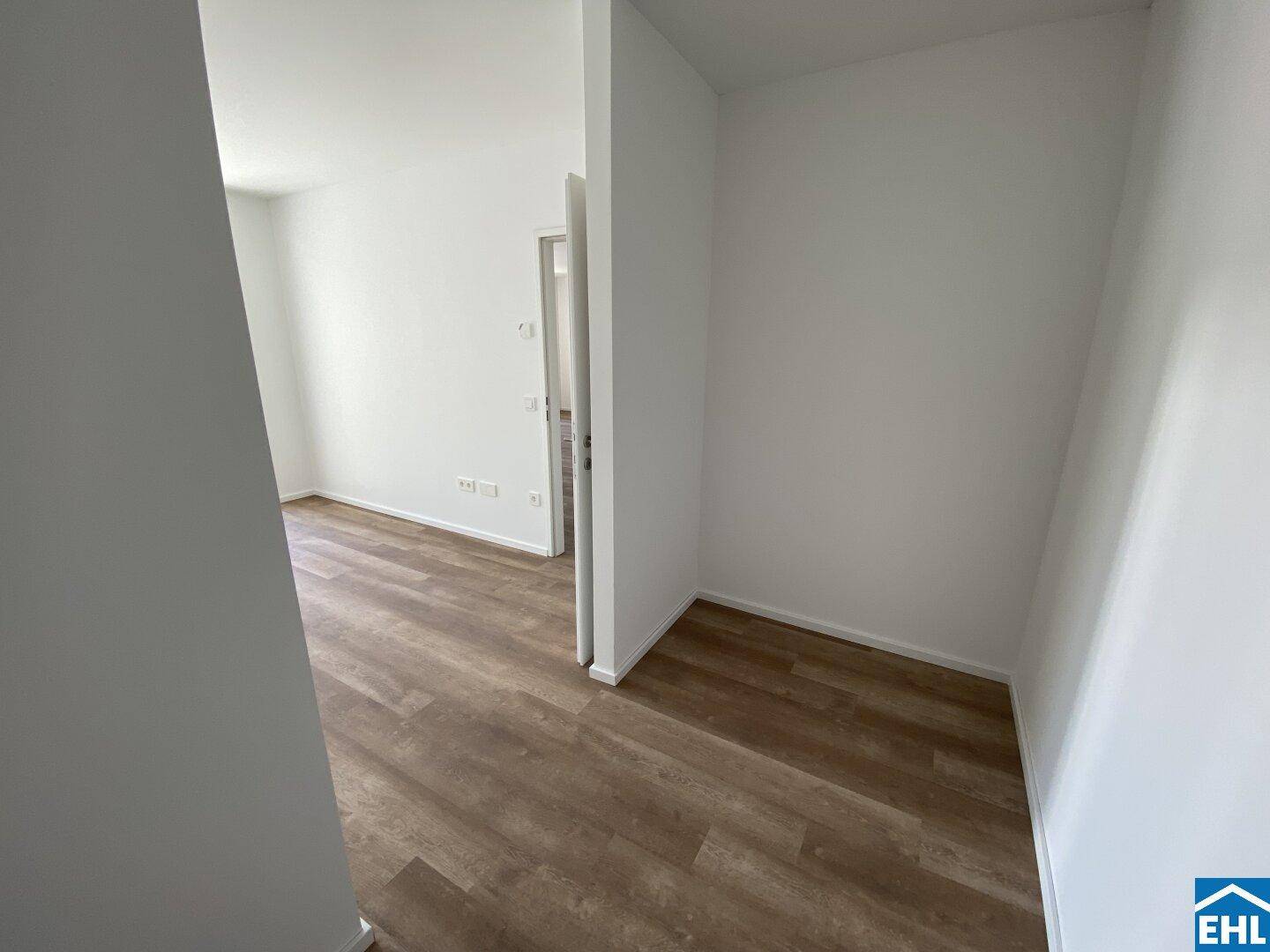 Heller Flurbereich mit modernem Laminatboden und weiß gestrichenen Wänden.