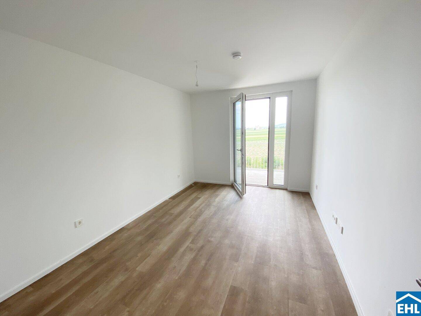 Helles Zimmer mit direktem Zugang zum Balkon und weitem Blick über die Felder.