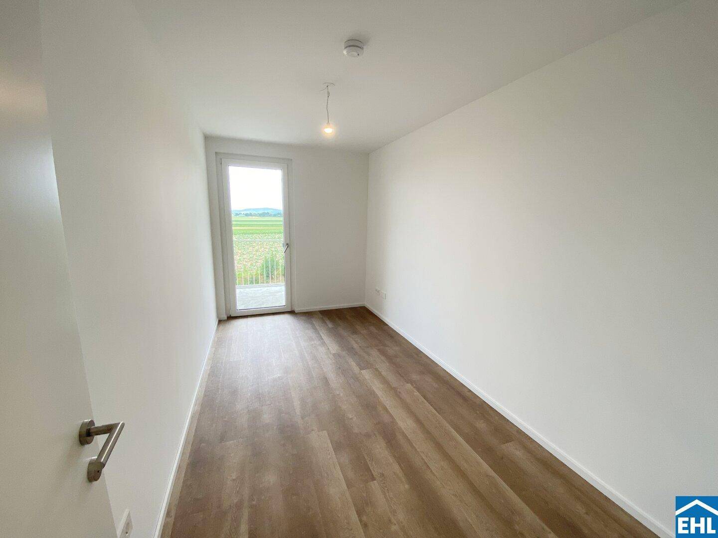 Ruhiges Zimmer mit Balkontür und Blick auf die umliegende Landschaft.