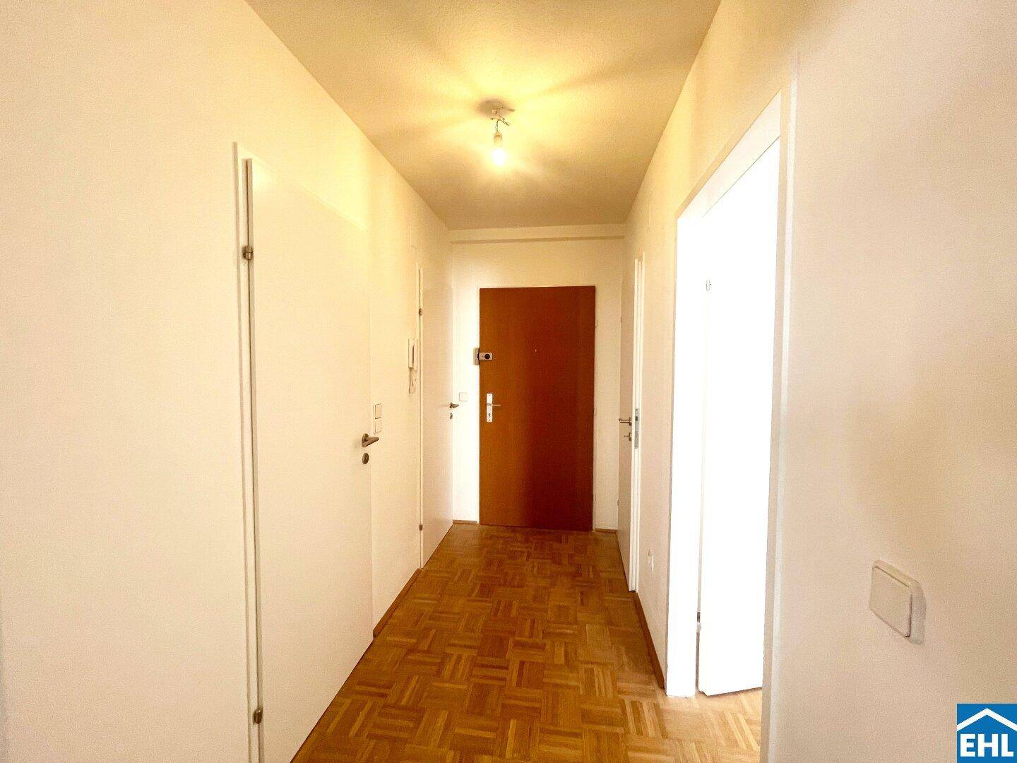 Heller Flur mit Parkettboden und mehreren Türen, verbindet die verschiedenen Räume.