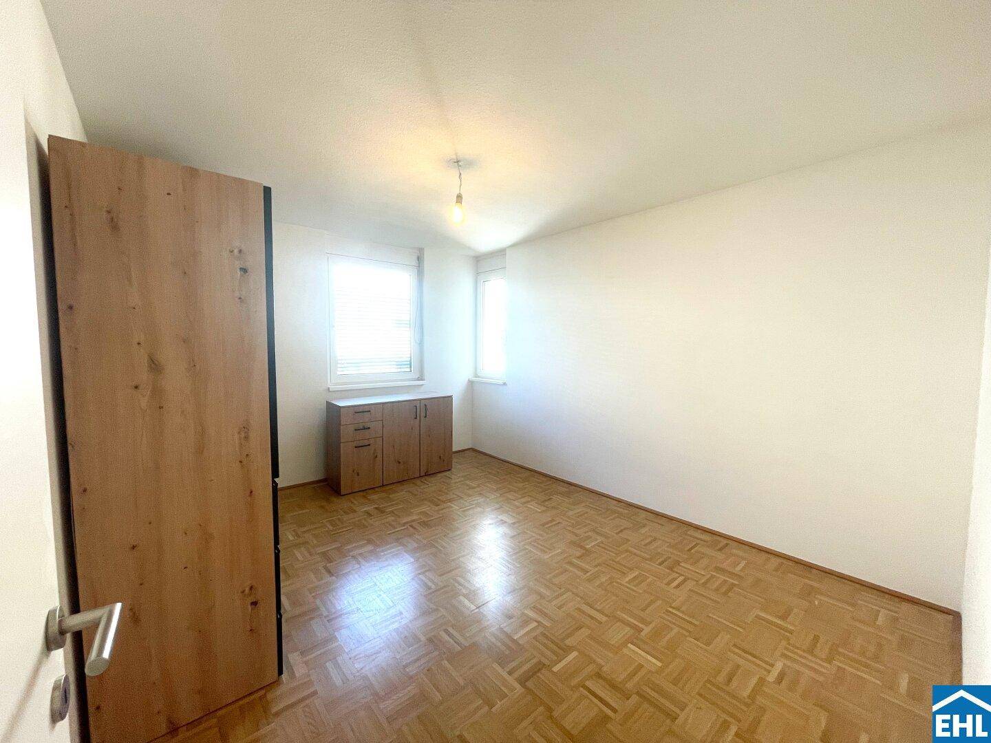 Schlafzimmer mit Parkettboden, Fenster und viel Tageslicht, bereit zur individuellen Gestaltung.