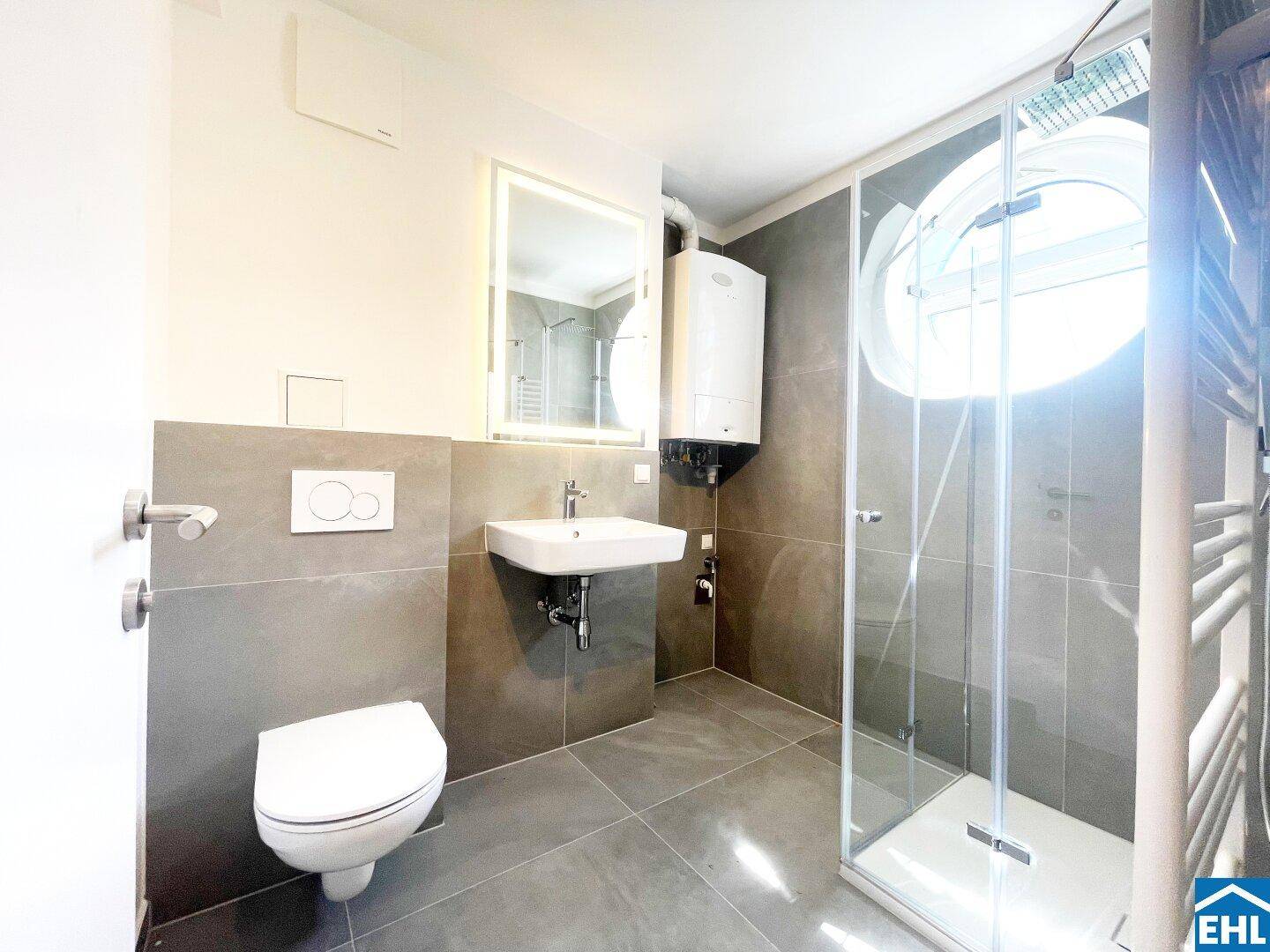 Modernes Badezimmer mit Dusche, Hänge-WC und Heizkörper.