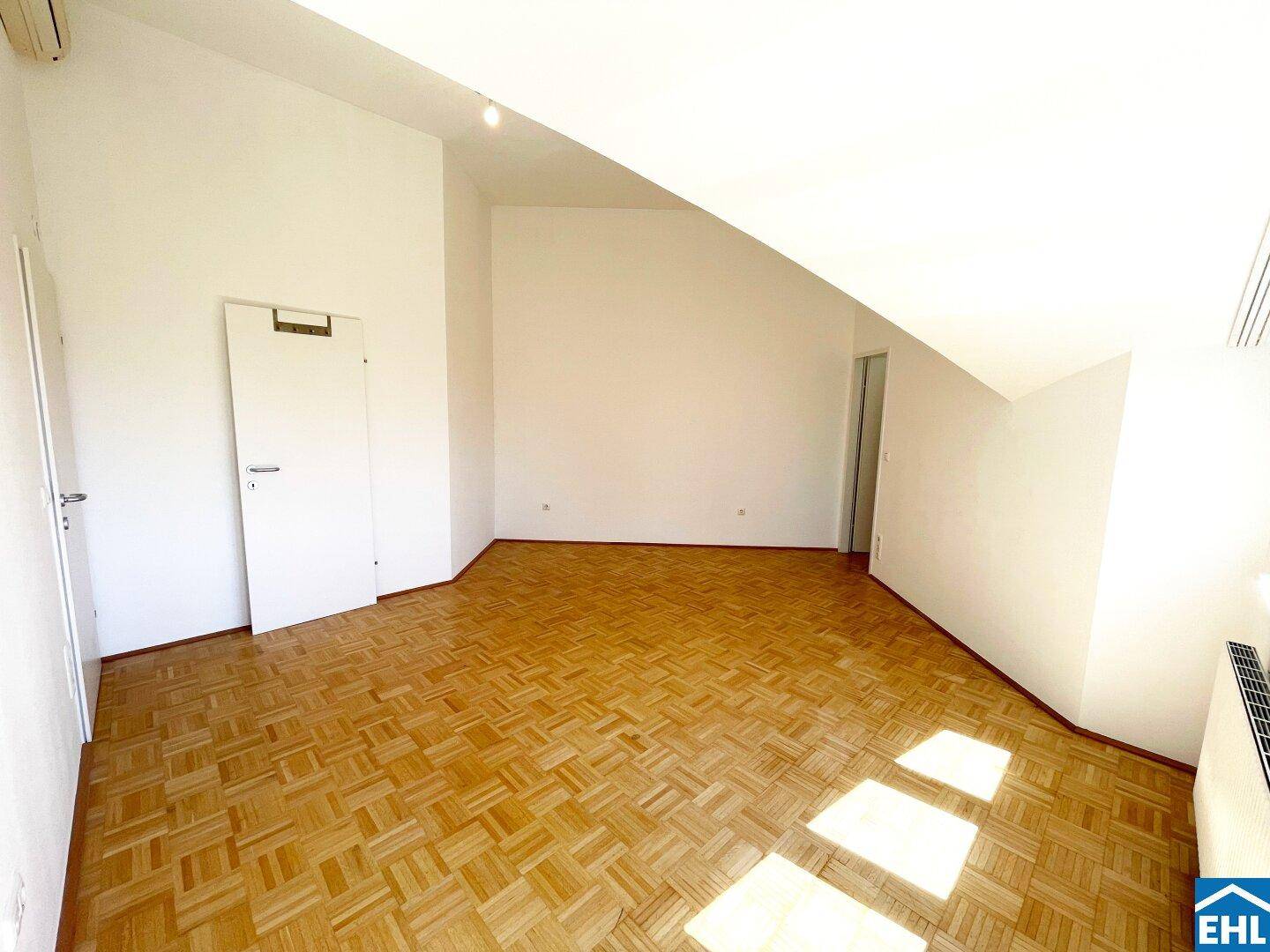 Kleiner, heller Raum mit Parkettboden und schrägen Wänden, ideal als Abstellraum oder Ankleidezimmer.