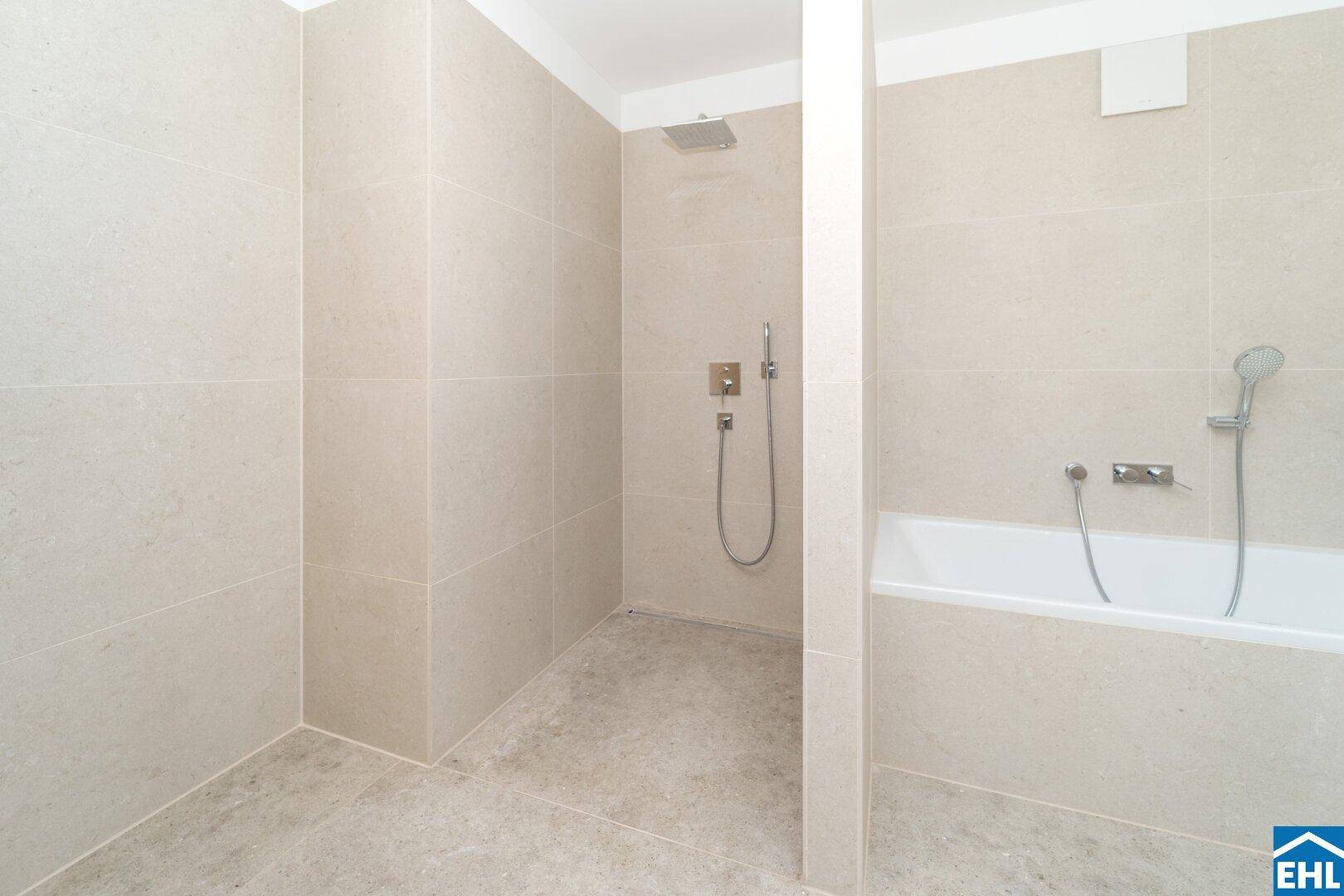 Helles Badezimmer mit beigefarbenen Fliesen, Regendusche und Badewanne, in neuwertigem Zustand.