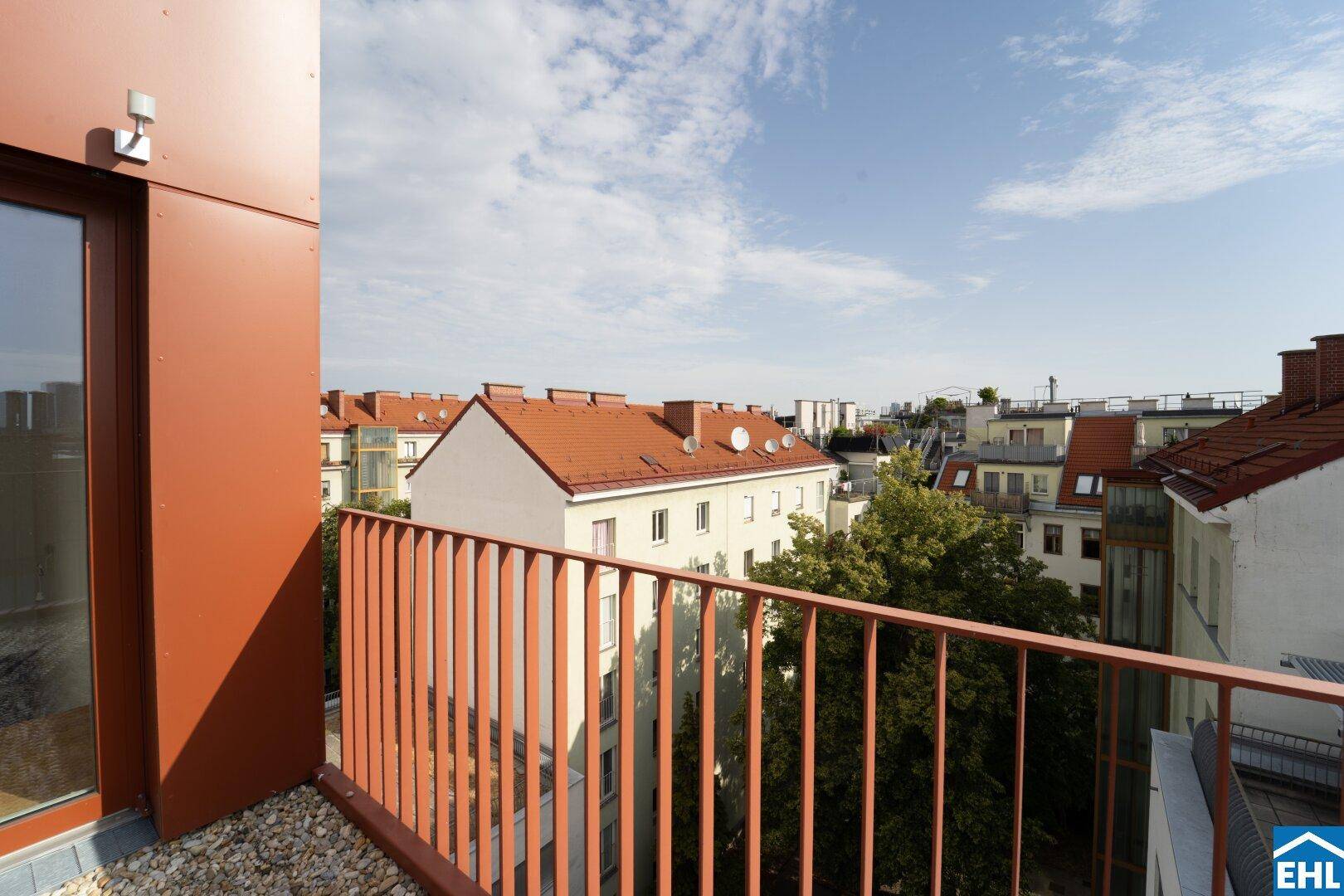Kleiner Balkon mit Blick auf die umliegenden Gebäude und Dächer der Stadt.