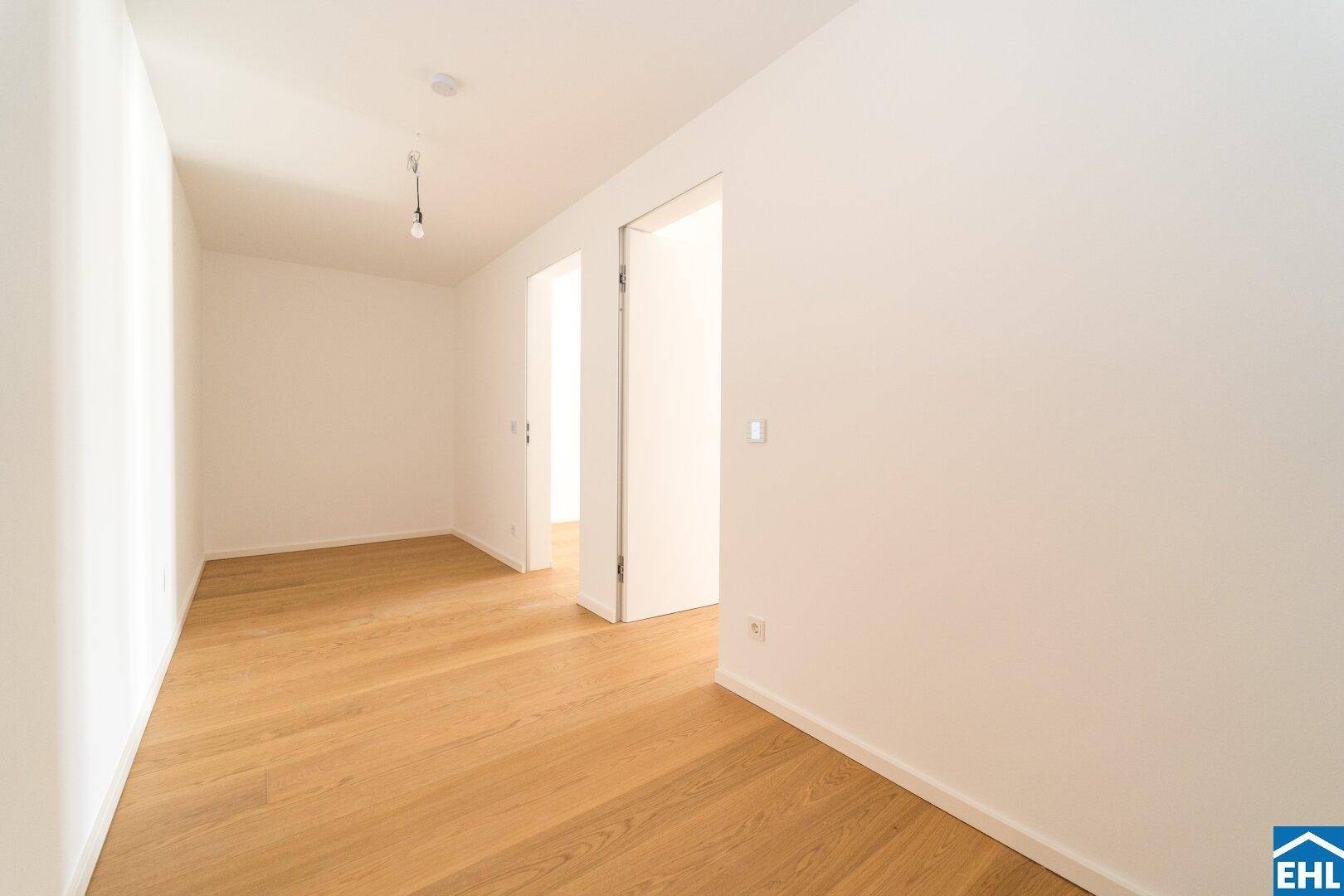 Heller Flur mit Parkettboden und Zugang zu weiteren Räumen der Wohnung.
