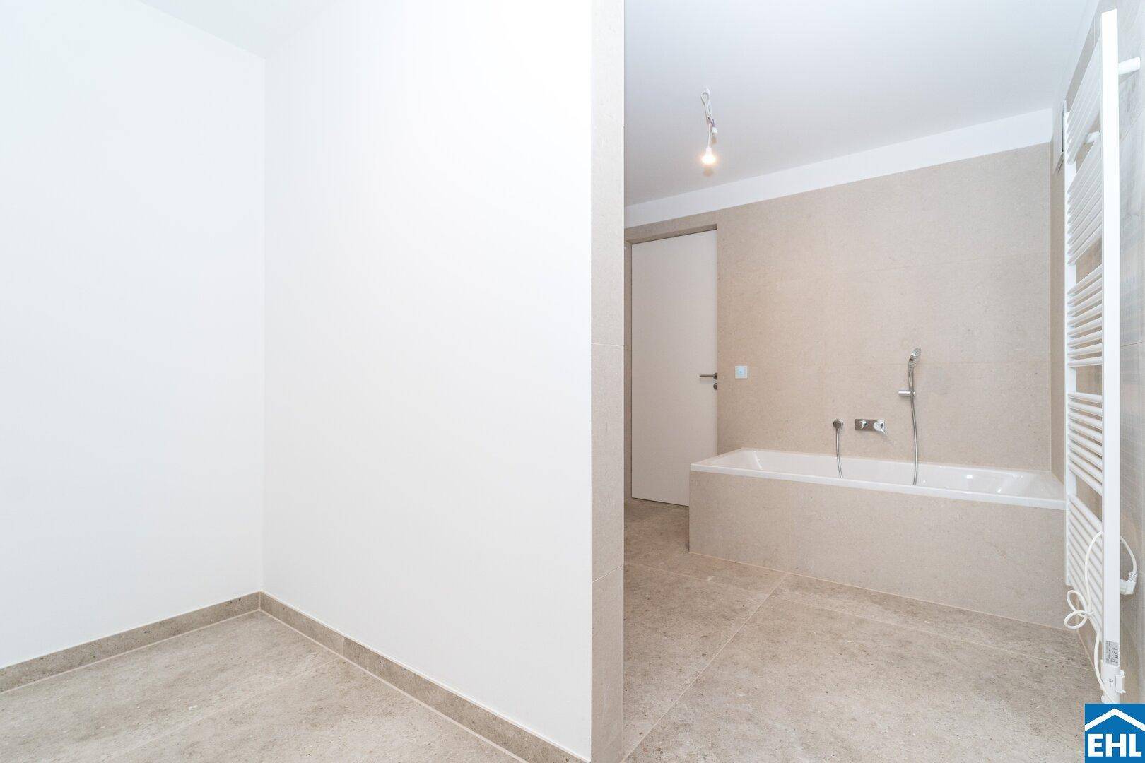 Geräumiges Badezimmer mit Badewanne und separatem Bereich für eine Dusche oder Toilette.