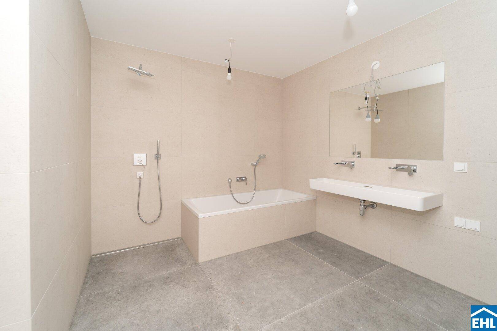 Modernes Badezimmer mit beigefarbenen Fliesen, Badewanne, separater Dusche und Einzelwaschbecken.