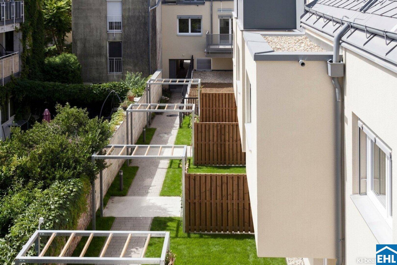Blick von oben auf die gepflegten Gärten und Wege eines modernen Wohnkomplexes.