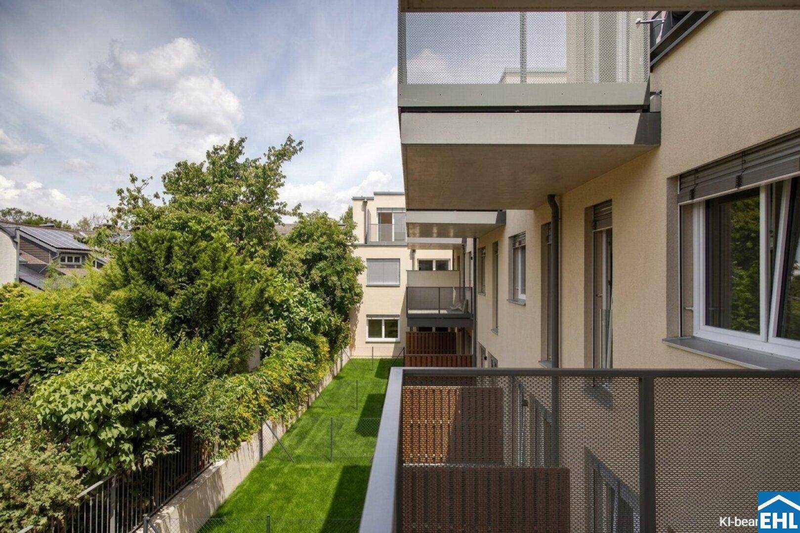 Blick von einem Balkon auf die grüne Umgebung und weitere Balkone des Wohnkomplexes.