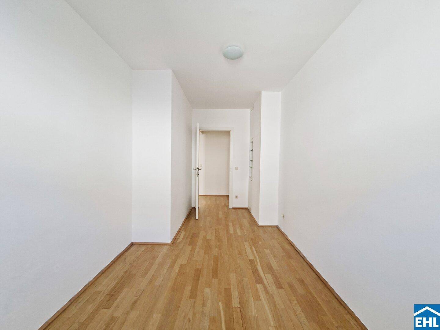 Langer, heller Flur mit Parkettboden und Zugang zu verschiedenen Zimmern.