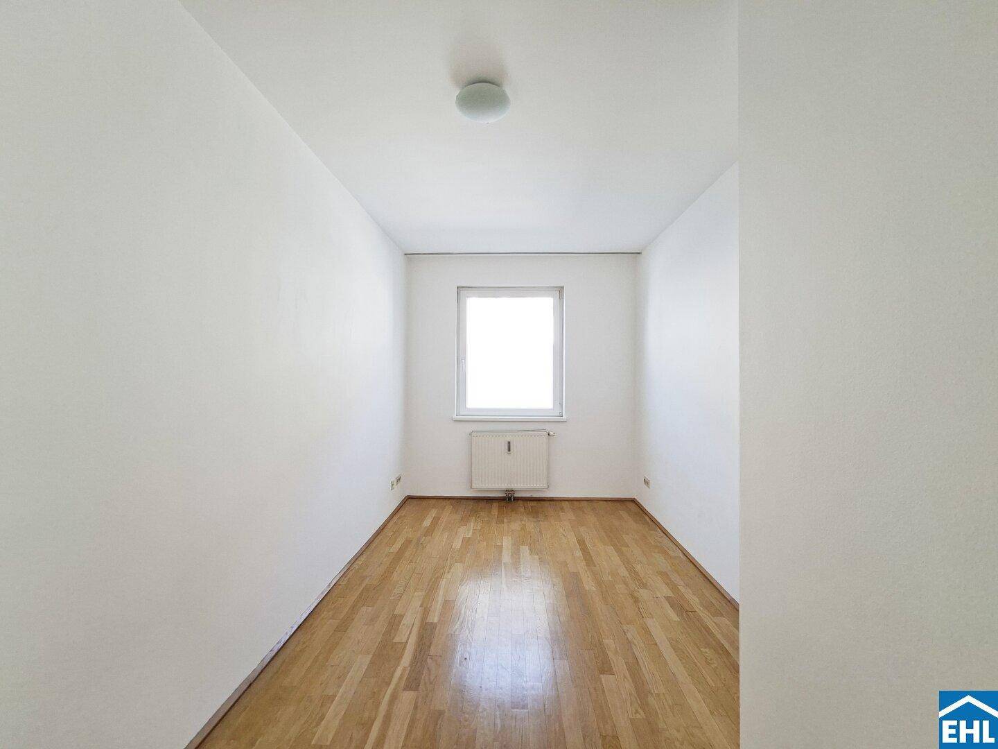 Kleines, helles Zimmer mit Parkettboden und einem Fenster.