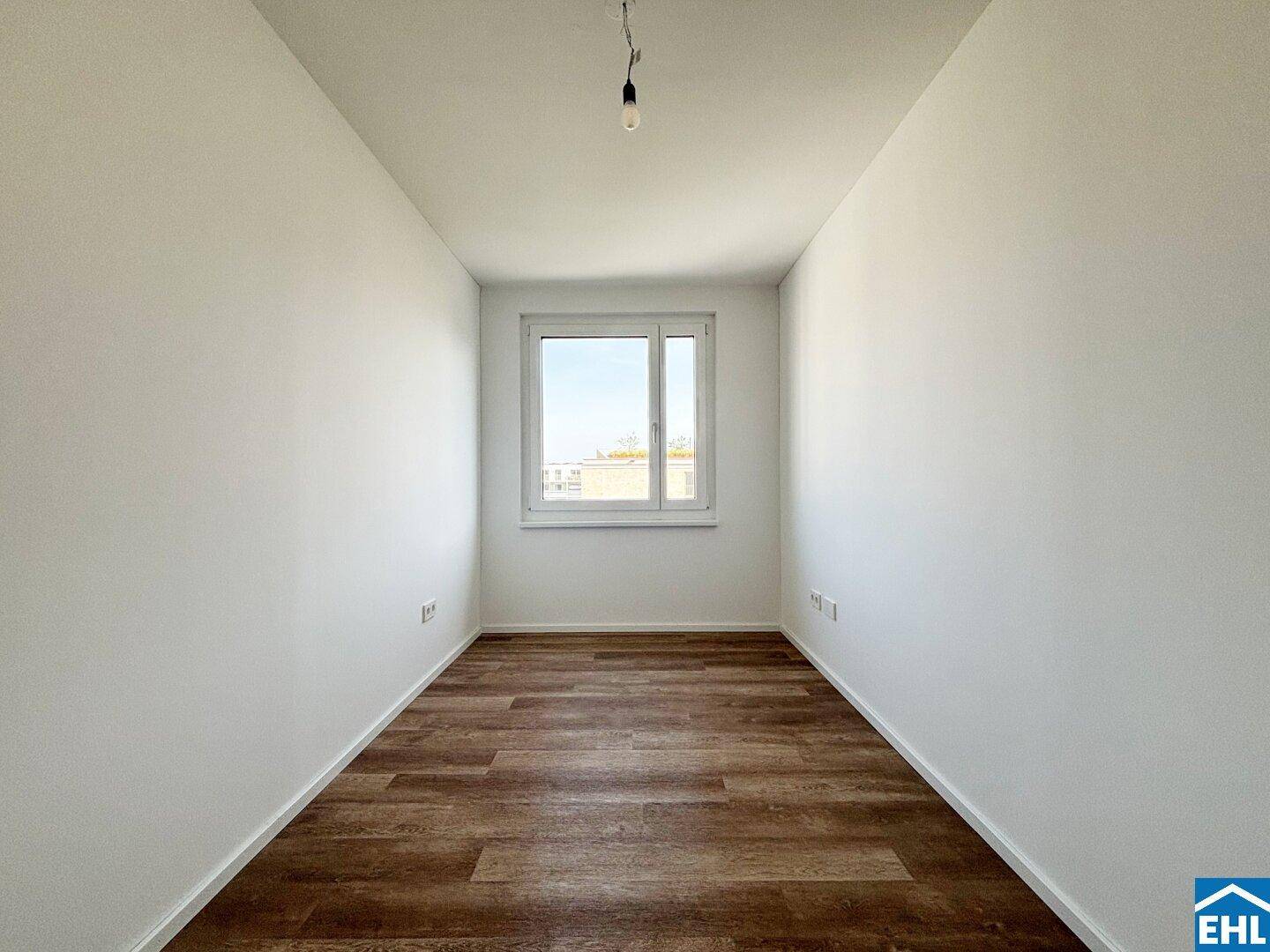 Kleines, helles Zimmer mit Laminatboden und einem Fenster, ideal als Kinder- oder Arbeitszimmer.