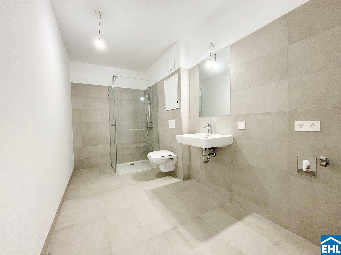 Modernes Badezimmer mit ebenerdiger Dusche, Wand-WC und großformatigen Fliesen.