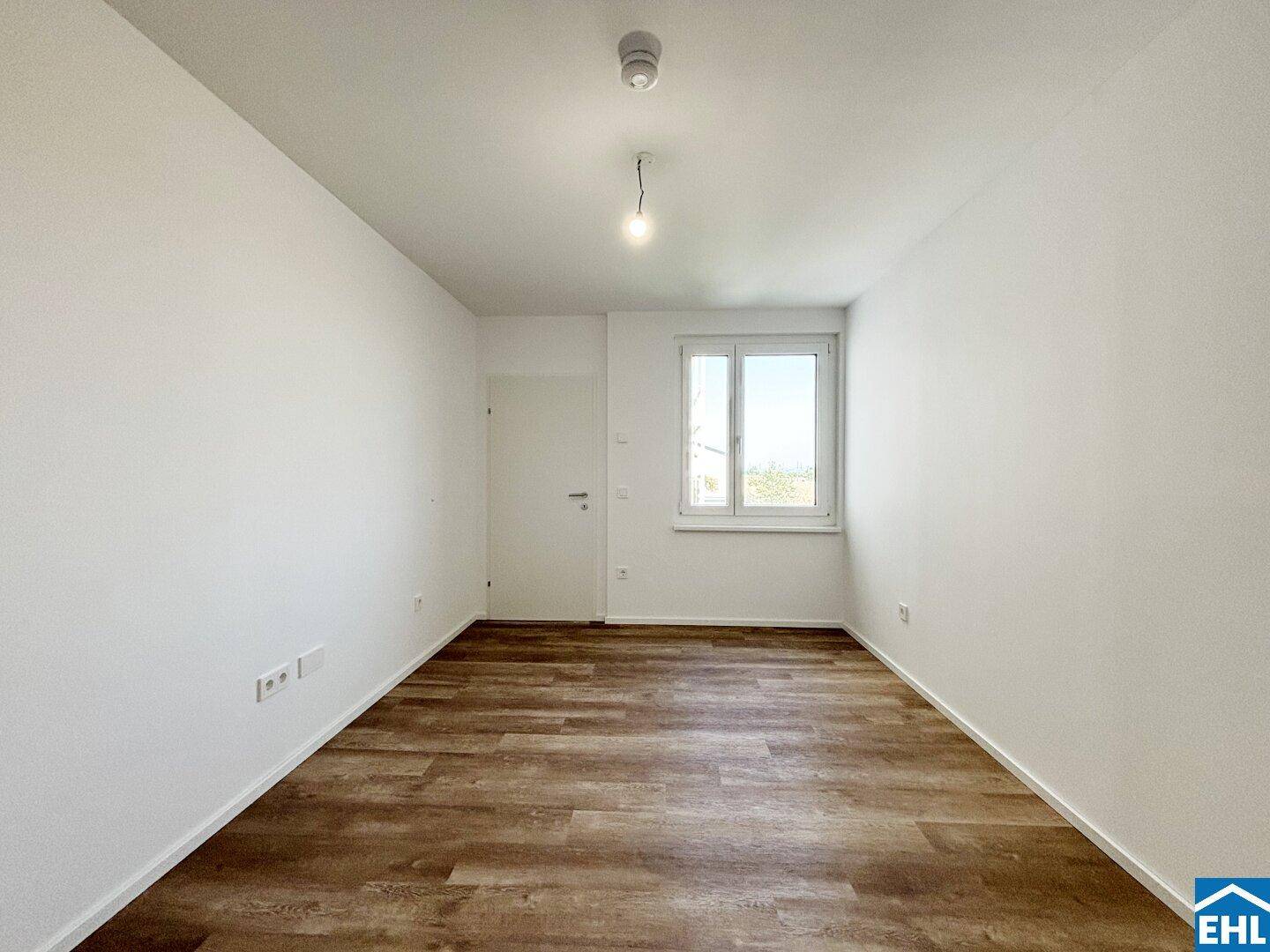 Helles Zimmer mit Laminatboden und Fenster, ideal als Schlaf- oder Arbeitszimmer nutzbar.