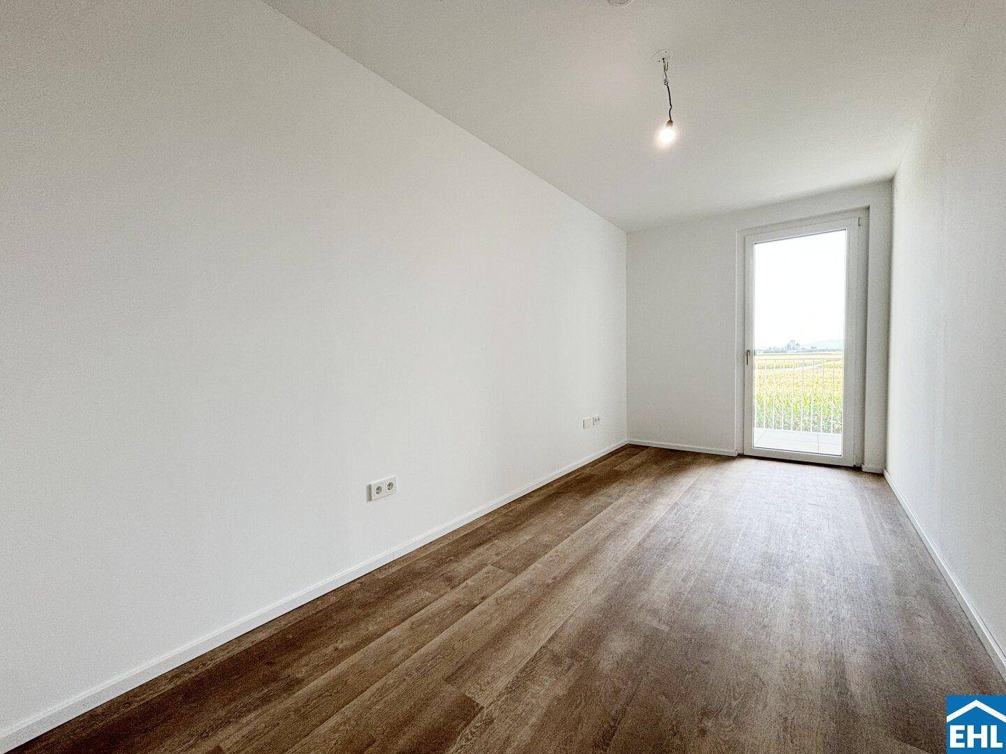 Geräumiges Zimmer mit Laminatboden und direktem Zugang zum Balkon für frische Luft.
